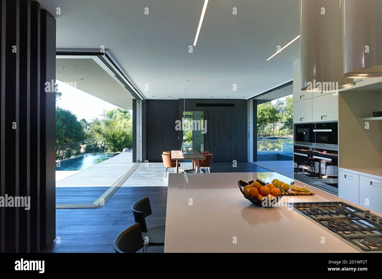 Innenansicht eines architektonisch gestalteten Hauses, Los Altos Hills, Califormia, USA, fertiggestellt 2016. Offener Plan mit Glasschiebewänden zur Terrasse und zum Swimmingpool. Stockfoto
