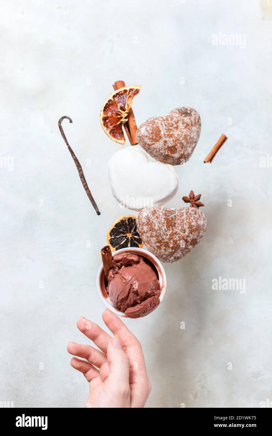 Wintereis mit Lebkuchengebäck. Lebkuchen und Eis fallen oder fliegen in Bewegung. Stockfoto