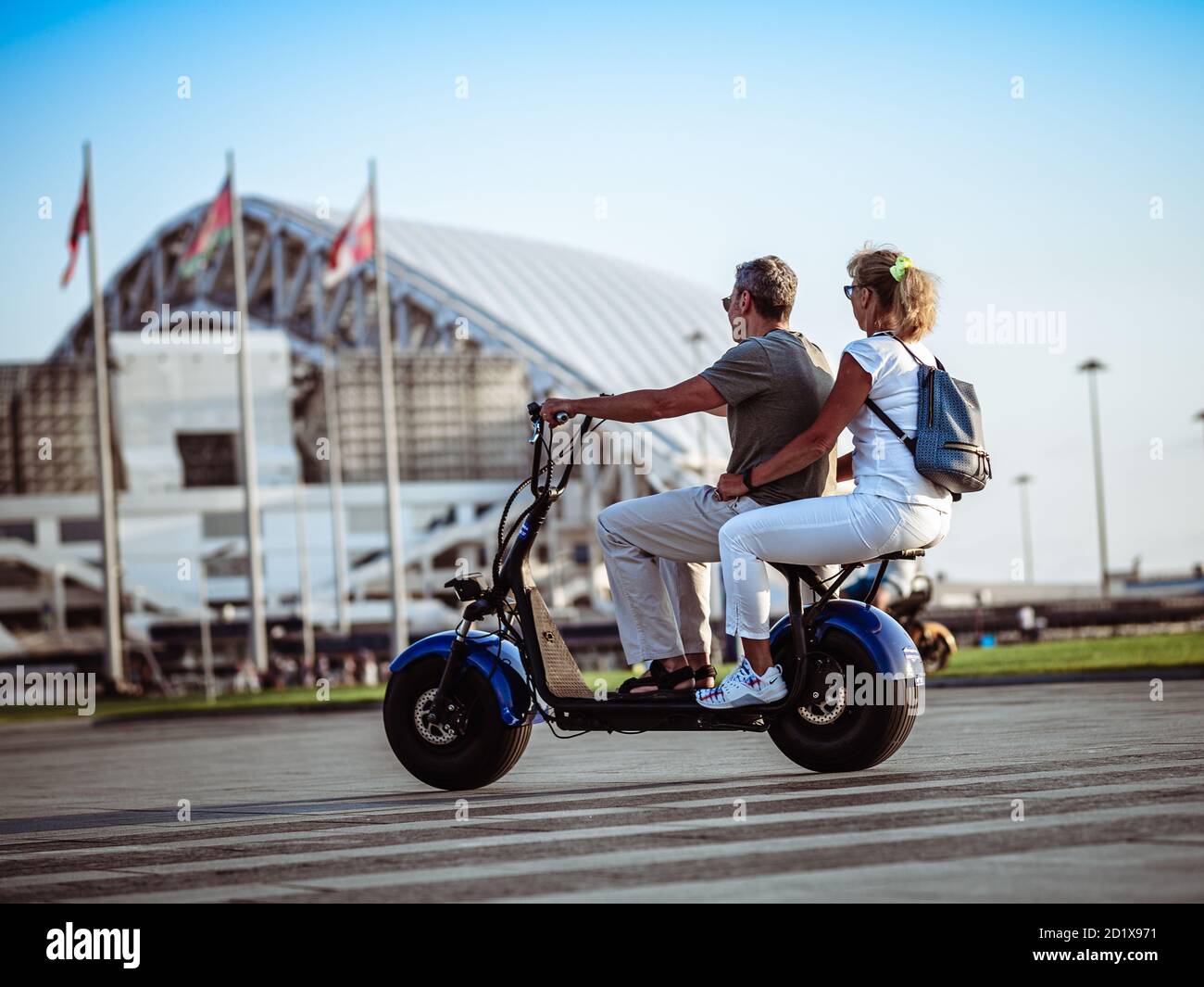 Sotschi, Russland - 16. September 2020: Mann und Frau auf einem zweisitzigen Elektroroller im Olympiapark. Modernes elektrisches Transportkonzept Stockfoto