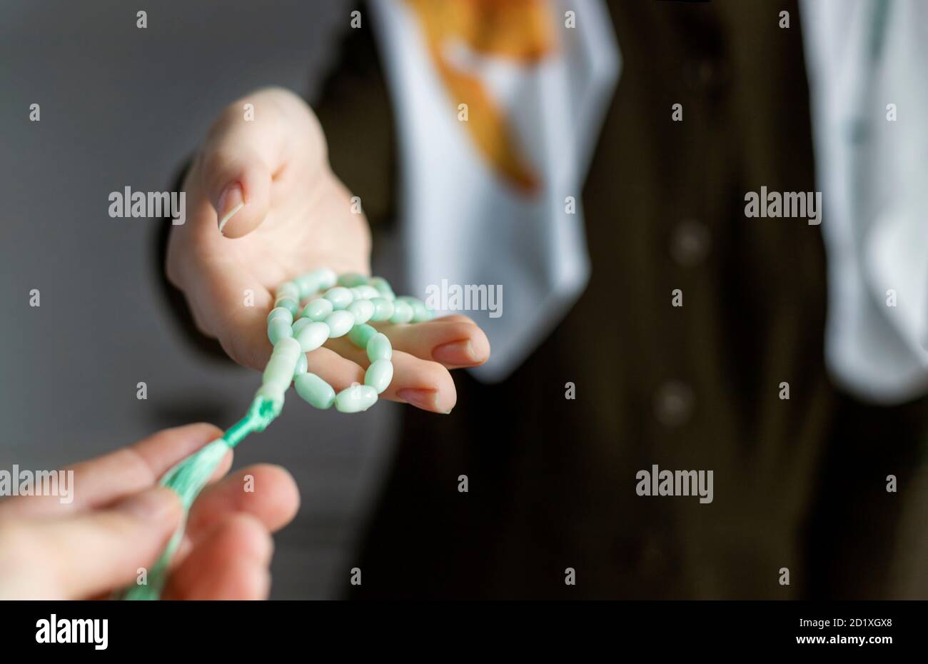 Die Hand der muslimischen Frau mit einem Rosenkranz. Selektiver Fokus Stockfoto