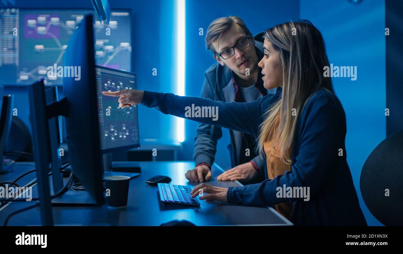 Männliche und weibliche Programmierer sprechen über Arbeit, Probleme gemeinsam lösen, Computer verwenden. Software Entwicklung Code Schreiben Website Design Datenbank Stockfoto