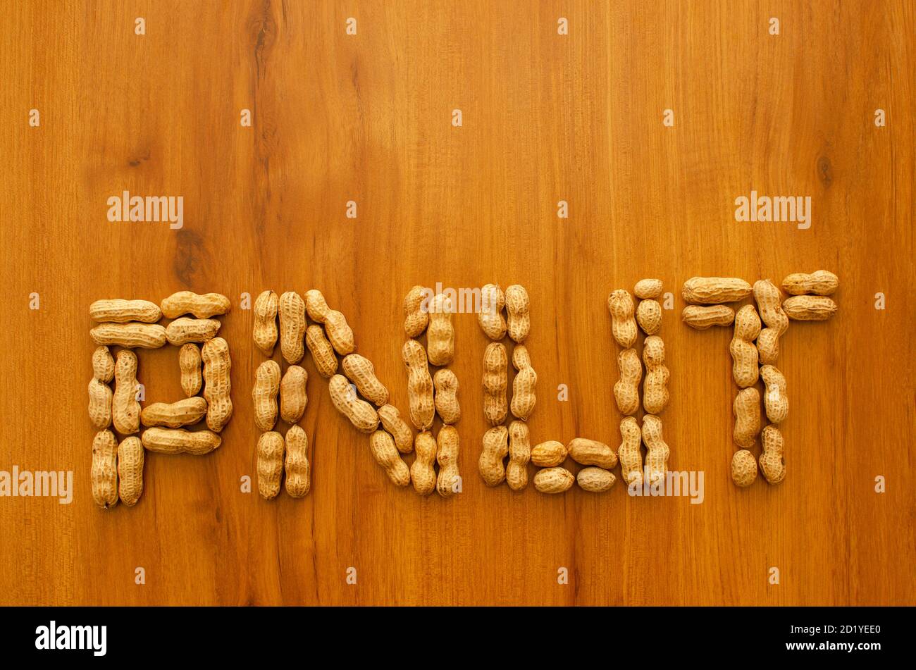PNUT Buchstaben mit Erdnüssen auf braunem Hintergrund erstellt. Stockfoto