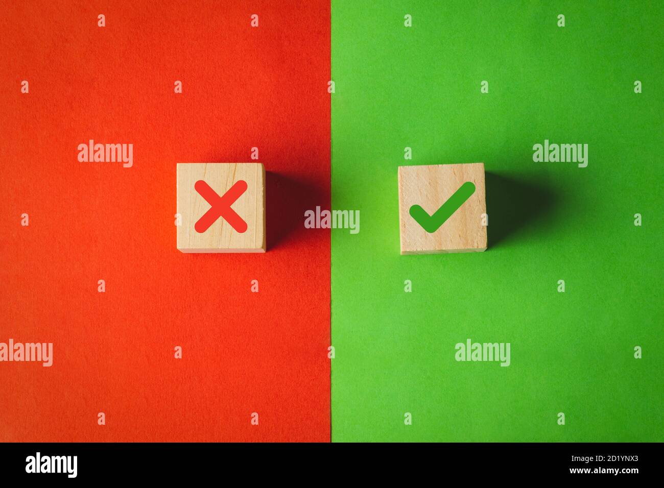 Wahr und falsch Symbole, Ja oder Nein auf Holzwürfeln auf rotem und grünem Hintergrund. Stockfoto