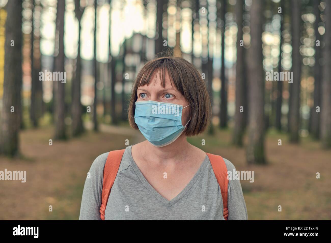 Casual Frau im Alltag Schutz Gesichtsmaske Konzept posiert im Park, trägt chirurgische Maske als neue normale Routine-Zubehör Stockfoto