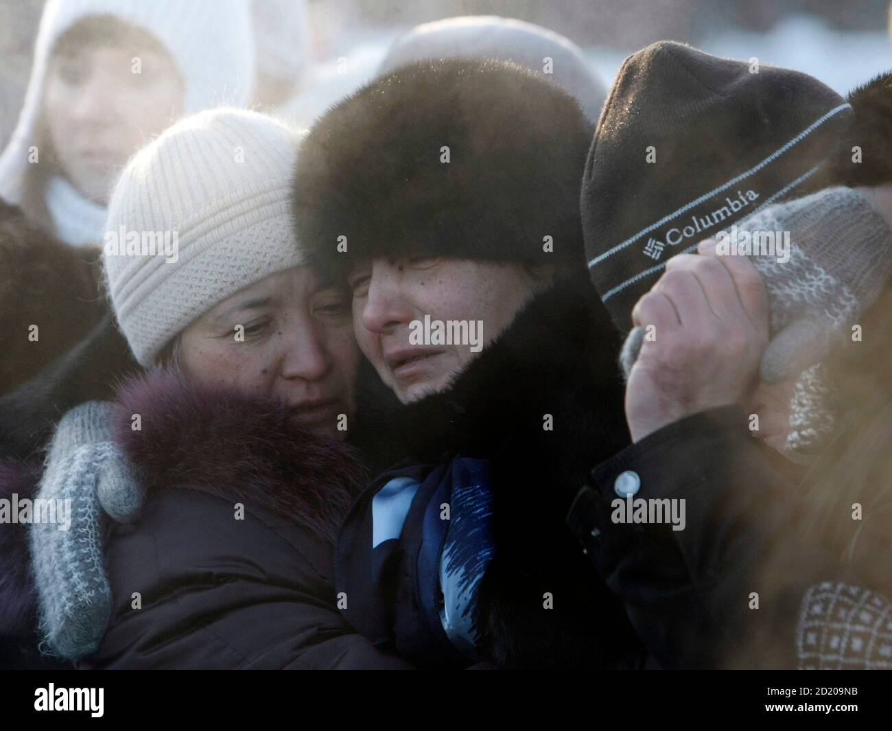 Die Mutter (C) von Liliya Kalashnikova, 30, ein Opfer der lahmen Gaul Nachtclub Feuer ist von Angehörigen während einer Beerdigung Zeremonie auf einem Friedhof außerhalb Perm, 1.150 km (720 Meilen) östlich von Moskau, 7. Dezember 2009 getröstet. Russland beobachtet einen nationalen Tag der Trauer am Montag für die 112 Opfer von einem Wochenende Nachtclub Blaze, als Ermittler intensiviert ihre Sonde in Sicherheitsverletzungen und Bestattungen fortgesetzt Feuer zul.  REUTERS/Denis Sinyakov (Russland-Desaster) Stockfoto