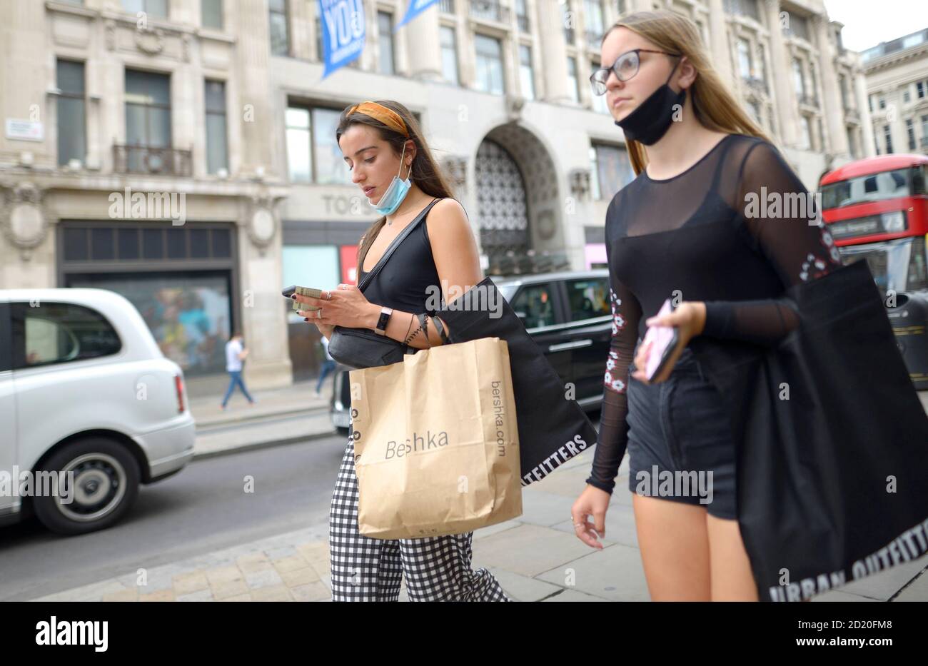 London, England, Großbritannien. Zwei junge Frauen mit Gesichtsmasken über ihren Chins in der Regent Street, 2020 Stockfoto