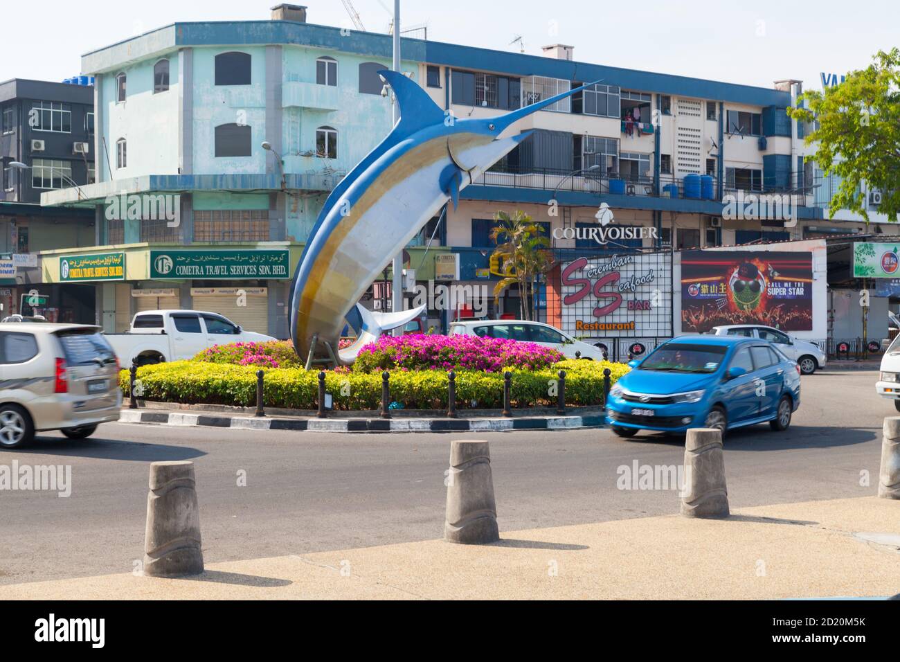 Kota Kinabalu, Malaysia - 17. März 2019: Marlin Statue montiert am Kreisverkehr im zentralen Bezirk von Kota Kinabalu, gehen gewöhnliche Menschen die Straße entlang Stockfoto