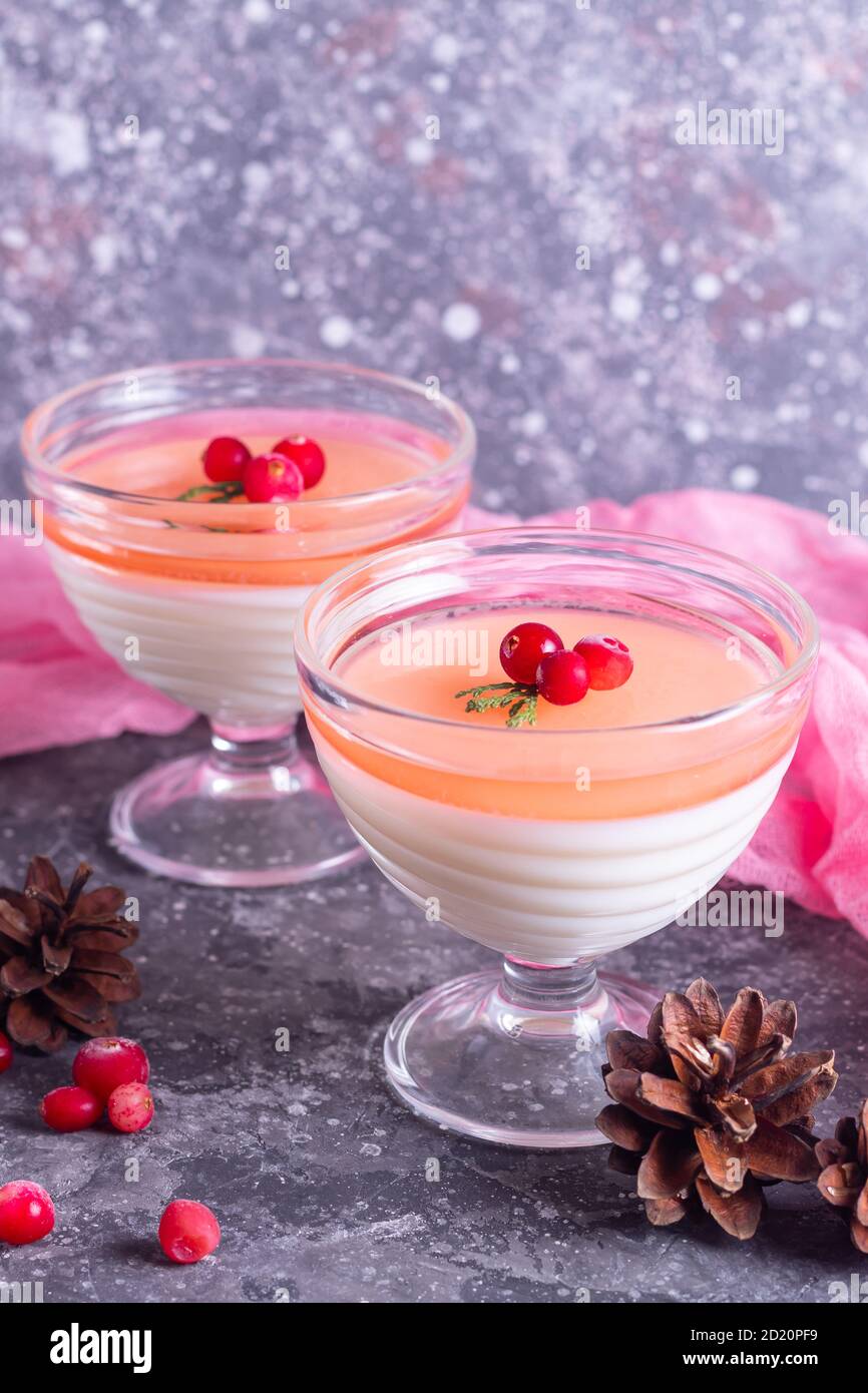 Italienische Dessert Panna Cotta zu weihnachten mit Sahne und Preiselbeere  In Glasschalen mit rosa Serviette und Kiefer pürieren Nadeln  Stockfotografie - Alamy