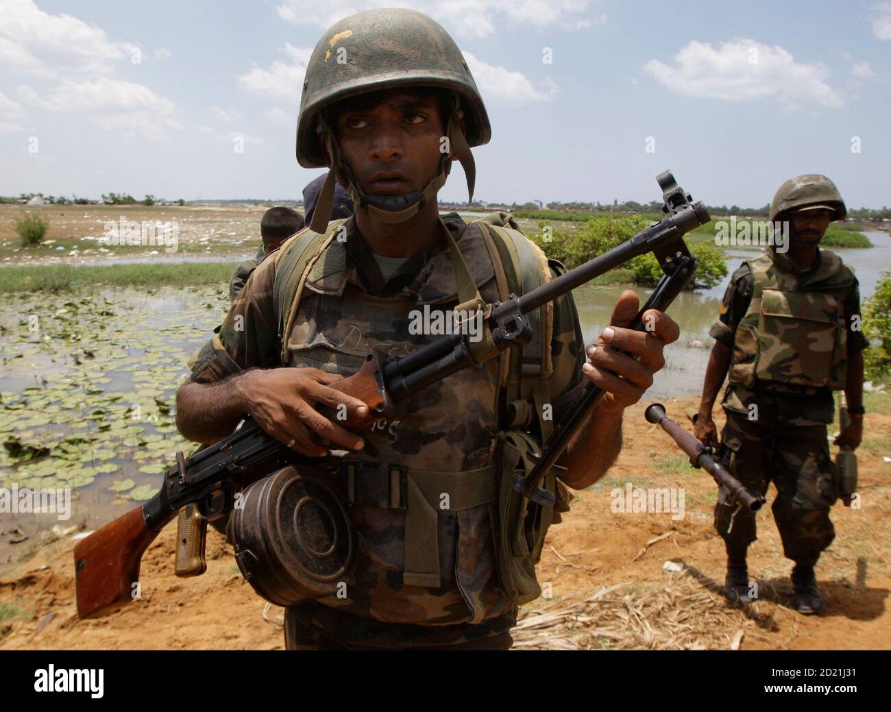 Soldaten der sri-lankischen Regierung stehen mit ihren Waffen in der Nähe der Stadt Putumatalan, gelegen am Stadtrand von "No Fire Zone" im Norden Sri Lankas 24. April 2009. Regierungstruppen und den Rebellen der Liberation Tigers of Tamil Eelam (LTTE) weiterhin das scheinbare Endspiel Asiens am längsten andauernden Krieg trotz Forderungen zum Schutz eine geschätzte Zehntausende von Zivilisten, die immer noch gefangen in einem Gebiet von der LTTE kontrollierten zu kämpfen. Militärsprecher Brigadier Udaya Nanayakkara fügte, Operationen, Asiens am längsten andauernden Krieg zu beenden, nicht zulassen würde, dass Truppen der Rebellen-Tasche in Richtung Stockfoto