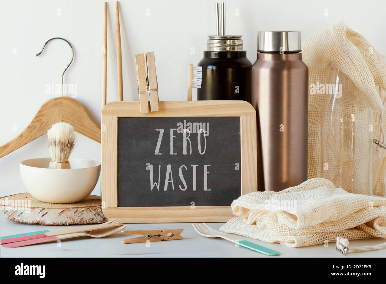 Der Text Zero Waste in einer Kreidetafel und einem Stapel von nicht-plastischen nachhaltigen Artikeln, wie Metall-Wasserflaschen, eine Glasflasche, Shopping Mesh Taschen oder reu Stockfoto