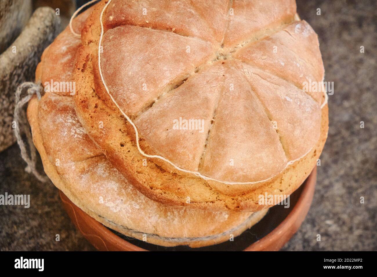 Das Brot gebacken in der Retro-Technologie des alten Rom. Rekonstruktion der Küche in der Antike. Römisches Brot, Rekonstruktion. Stockfoto