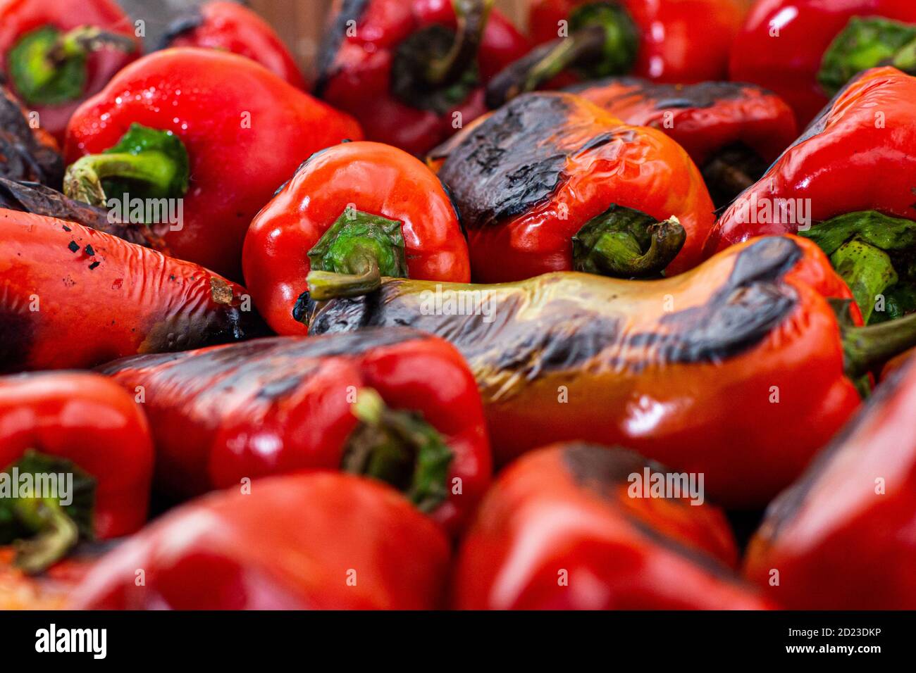 Rote Paprika rösten auf einem Holzofen in Vorbereitung für die Herstellung ajvar, ein traditionelles serbisches Gericht Stockfoto