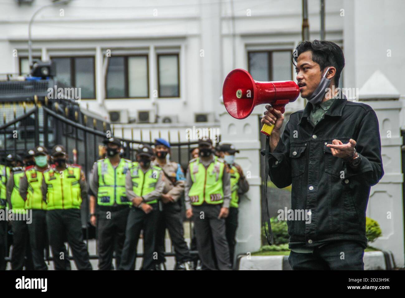 Bandung, Indonesien. Oktober 2020. Ein Protestler spricht während des Protestes durch ein Megaphon vor dem Parlamentsbüro. Studenten protestierten gegen den Omnibus-Gesetzentwurf der Regierung zur Schaffung von Arbeitsplätzen, der das Wirtschaftswachstum ankurbeln und Arbeitsplätze schaffen sollte, was ihrer Meinung nach die Arbeitnehmer ihrer Rechte berauben und die Umwelt in Indonesien untergraben würde. Kredit: SOPA Images Limited/Alamy Live Nachrichten Stockfoto