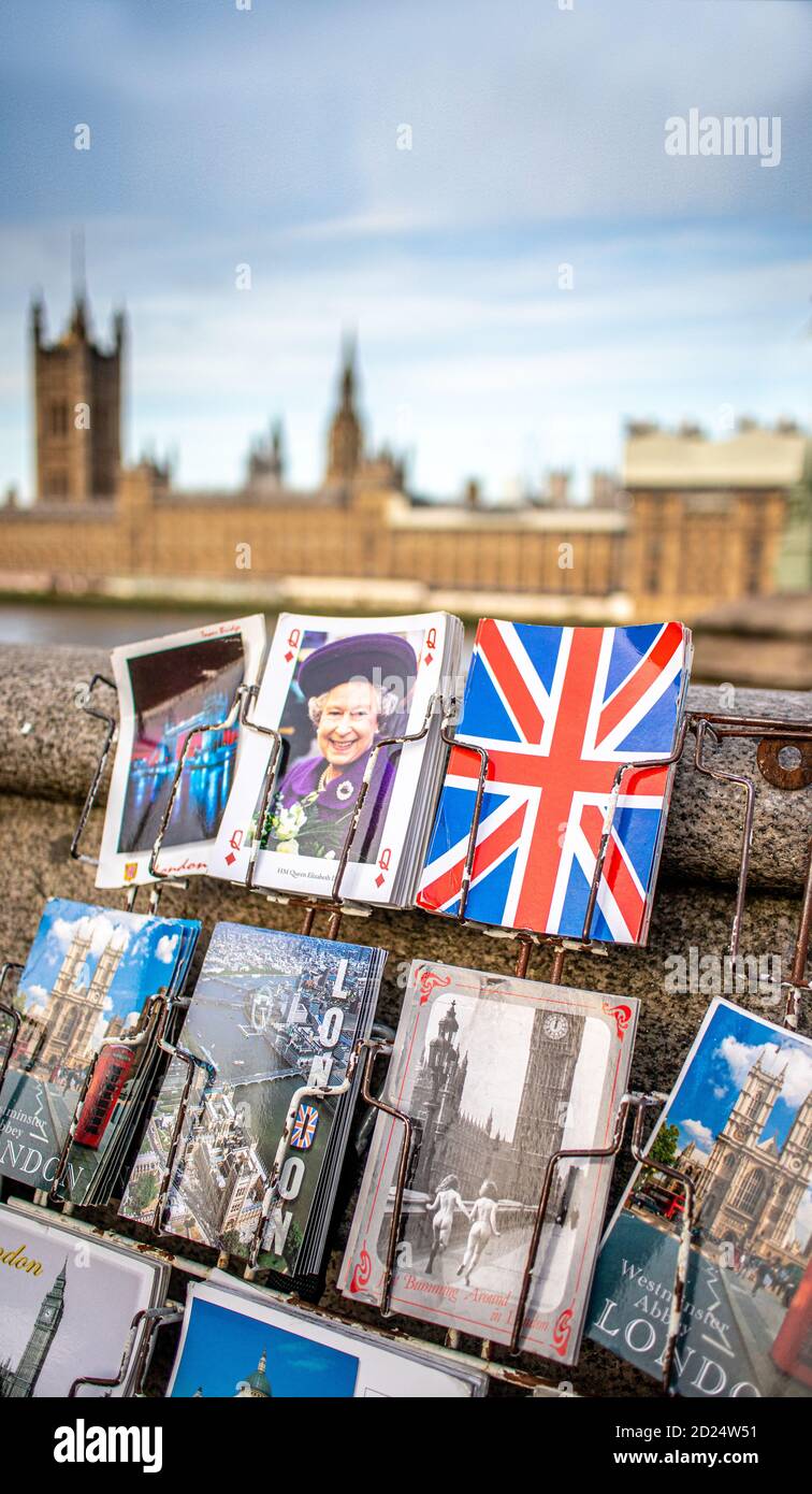 Auswahl von bunten London Postkarten mit einem verschwommenen Houses of Parliament im Hintergrund. Stockfoto