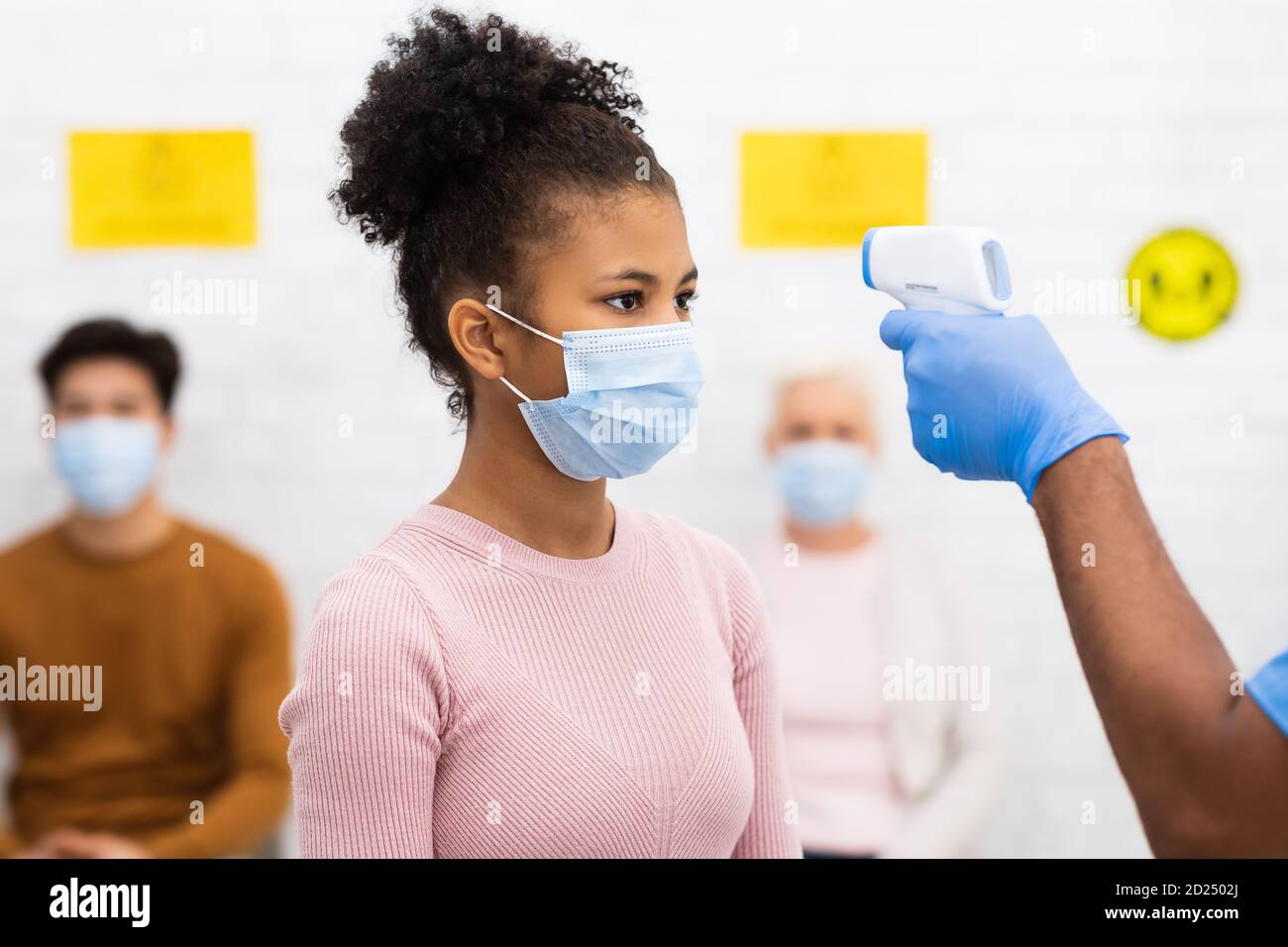 Medizinische Arbeiter Tun Temperatur Screening Für Patient Mädchen In Der Klinik, Stockfoto