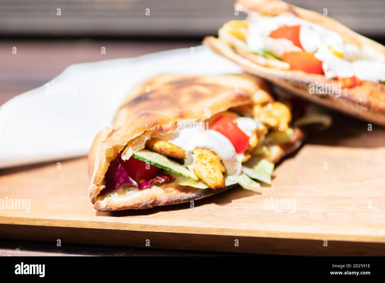 Gesundes gegrilltes Chicken Sandwich mit hausgemachtem Baguette auf einem Holzteller. Stockfoto