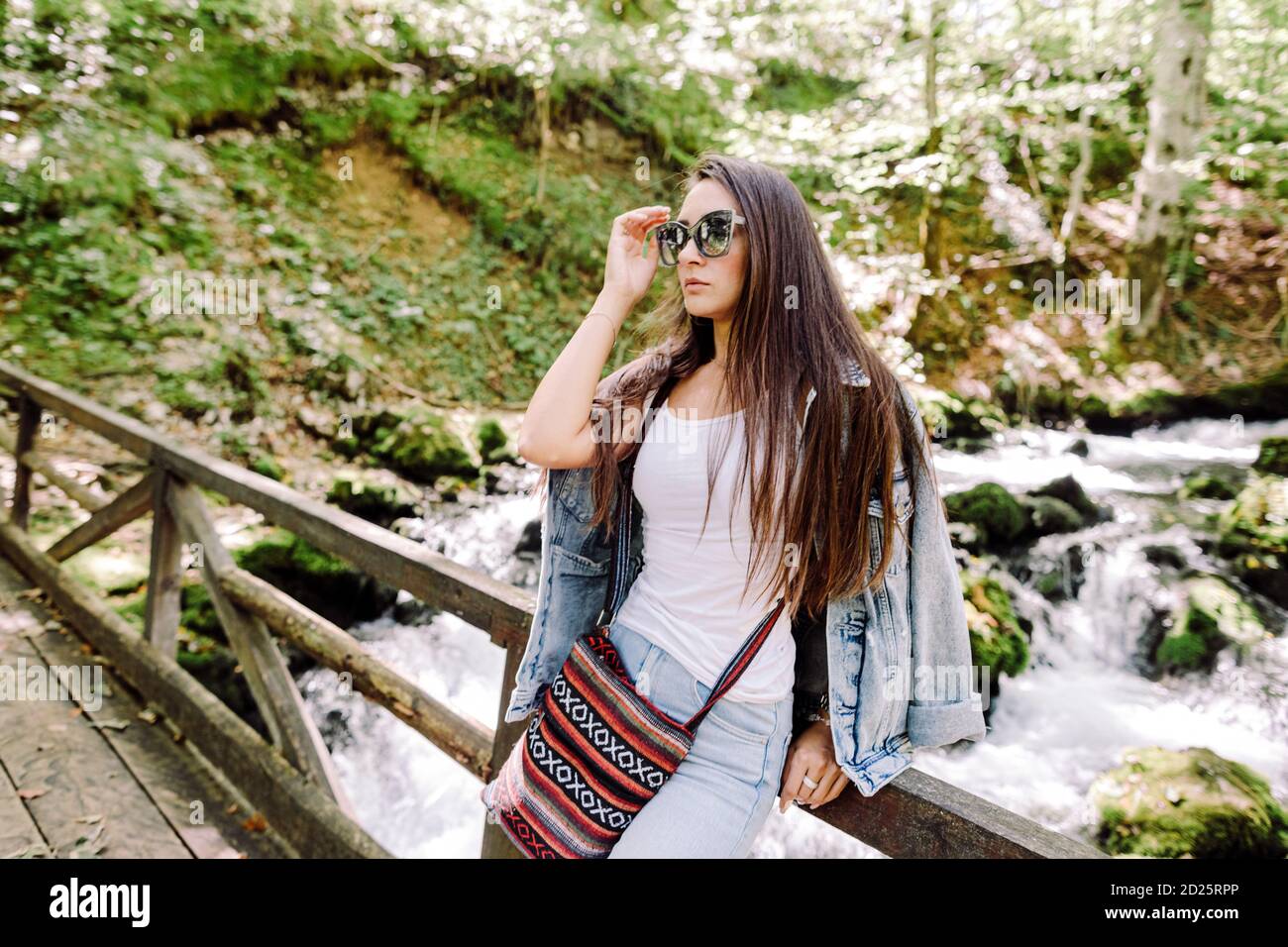 Frau entspannen im Herbstwald mit Wasserfall Hintergrund Stockfoto