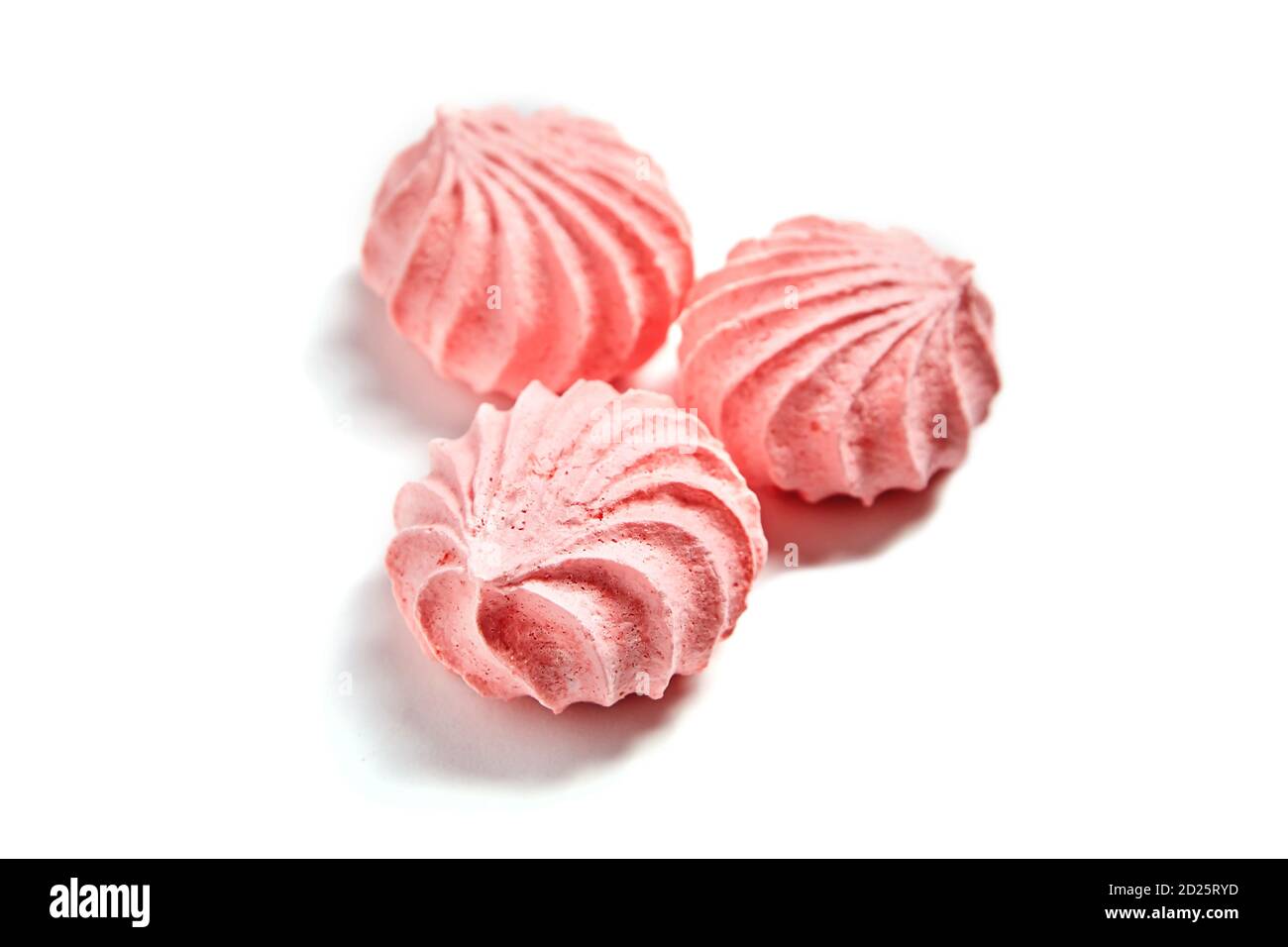 Drei Meringue Cookies. Baisenküsse in rosa Farbe. Luftige und praktisch schwerelose Kekse auf Basis von Eiweiß und Puderzucker. Isoliert auf w Stockfoto