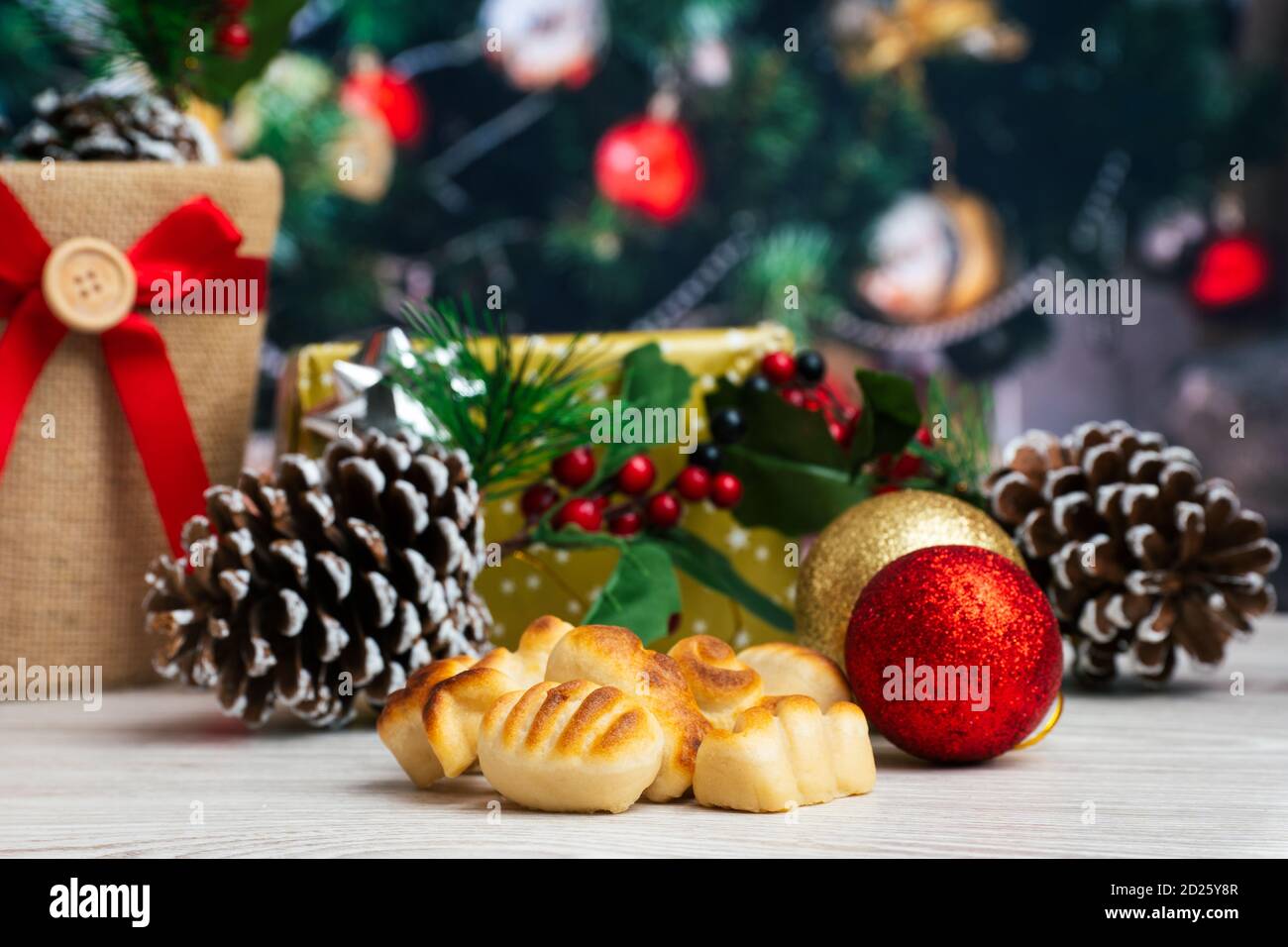 Weihnachtshintergrund mit Marzipan, Geschenke, Tannenzapfen und Baum Stockfoto