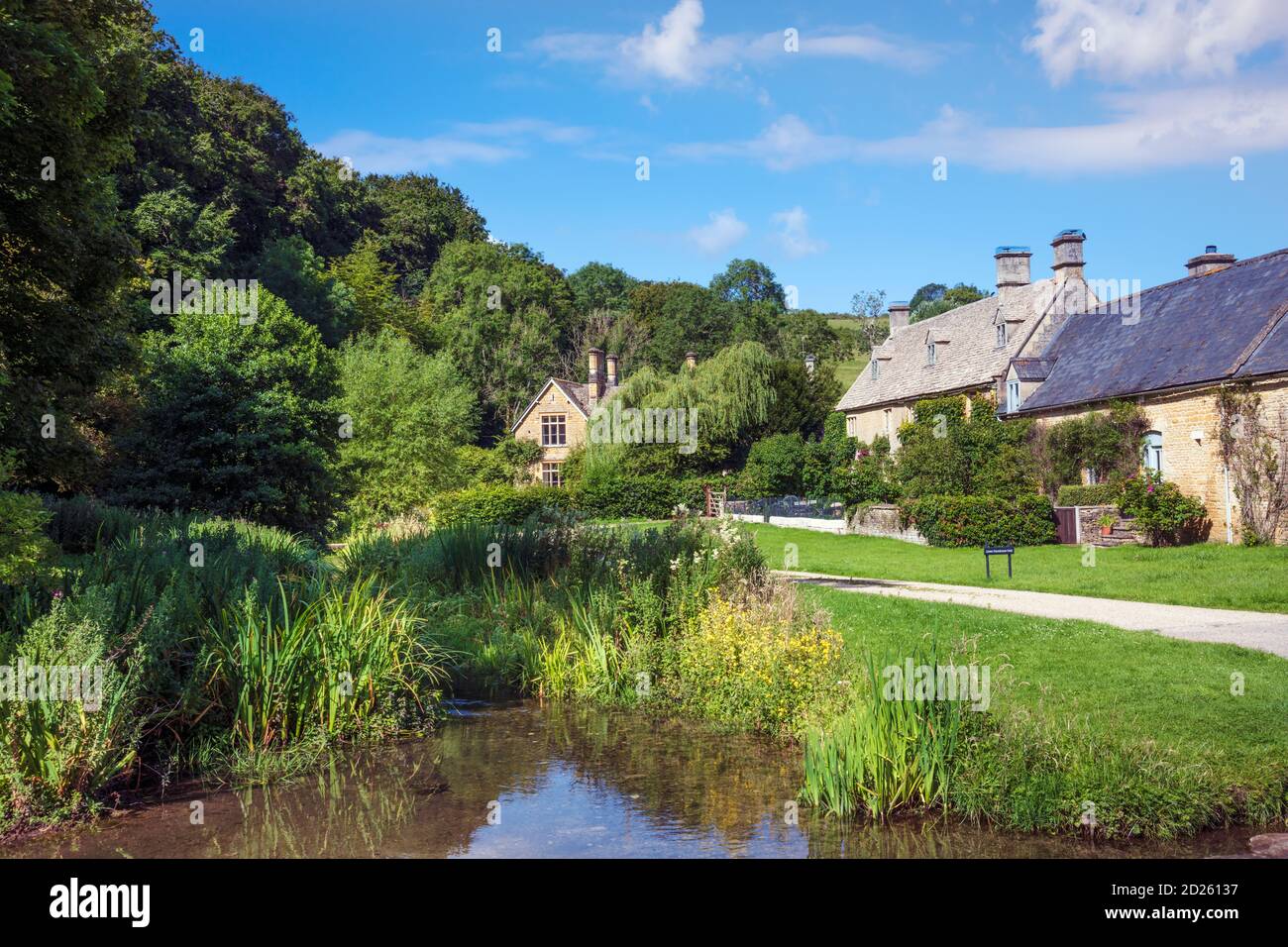 Großbritannien, Gloucestershire, Cotswolds. Sommer Blick auf einen Bach und traditionelle Hütten im Dorf Lower Slaughter in der Nähe von Stow-on-the-Wold Stockfoto