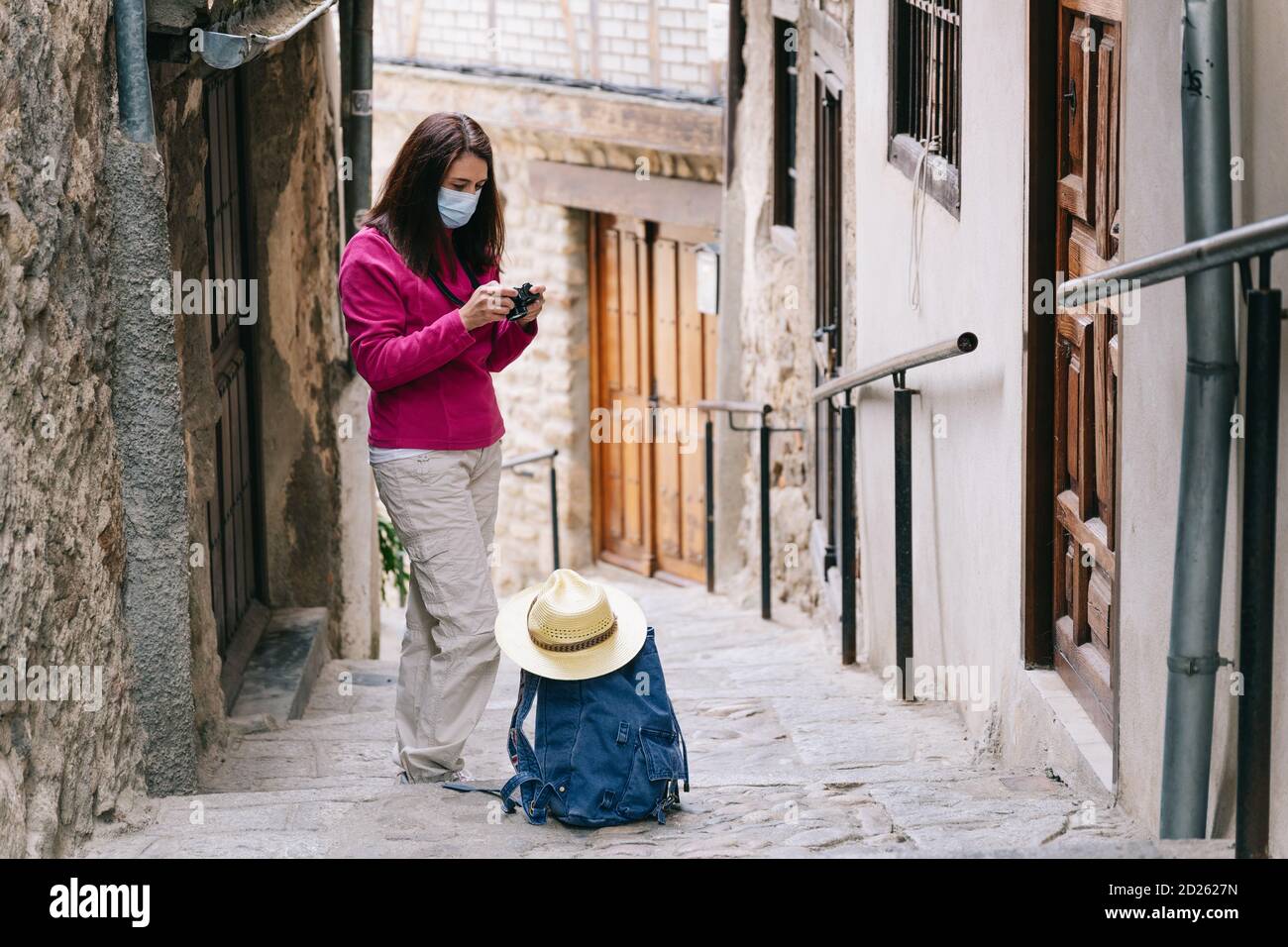 Freelance Frau tun Touring mit Maske Überprüfung Fotos auf Kamera Stockfoto