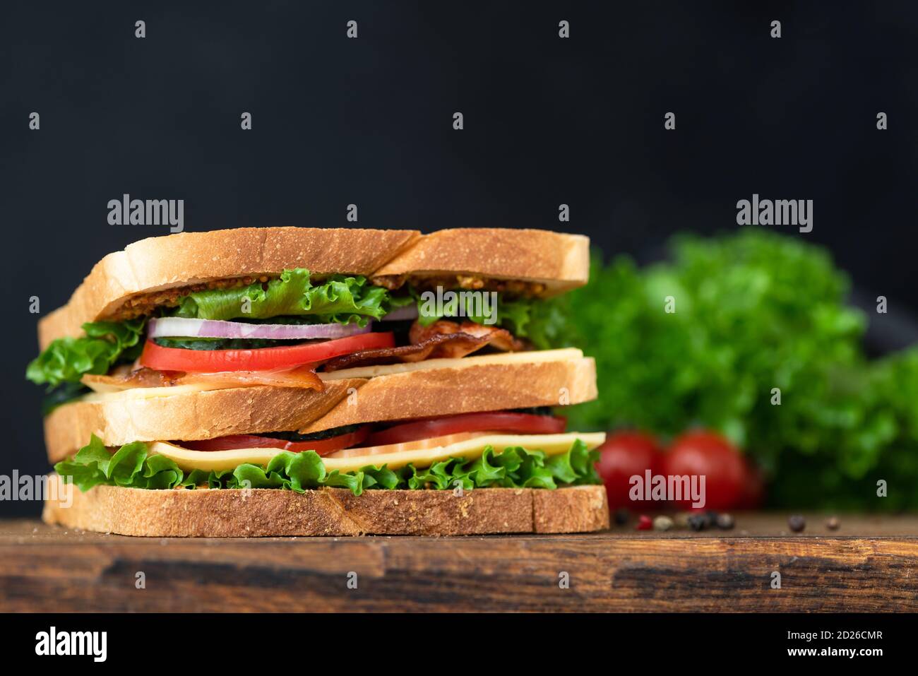 Köstliches Bacon Club Sandwich auf schwarzem Hintergrund mit Kopierplatz Stockfoto