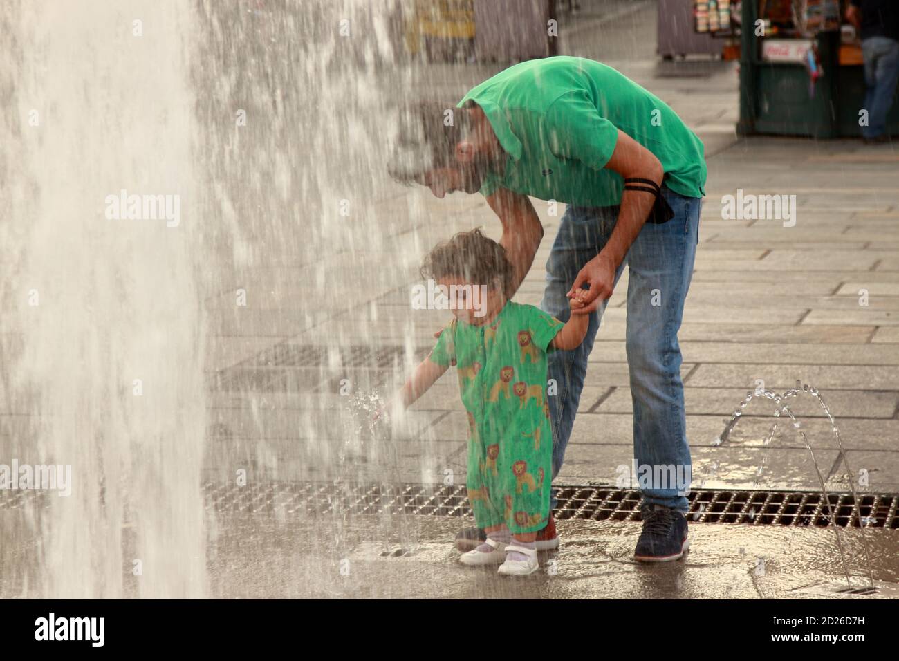 Turin - september 2020: Ein Vater lässt seine Tochter in einem Stadtbrunnen in der Nähe des königlichen Palastes spielen Stockfoto