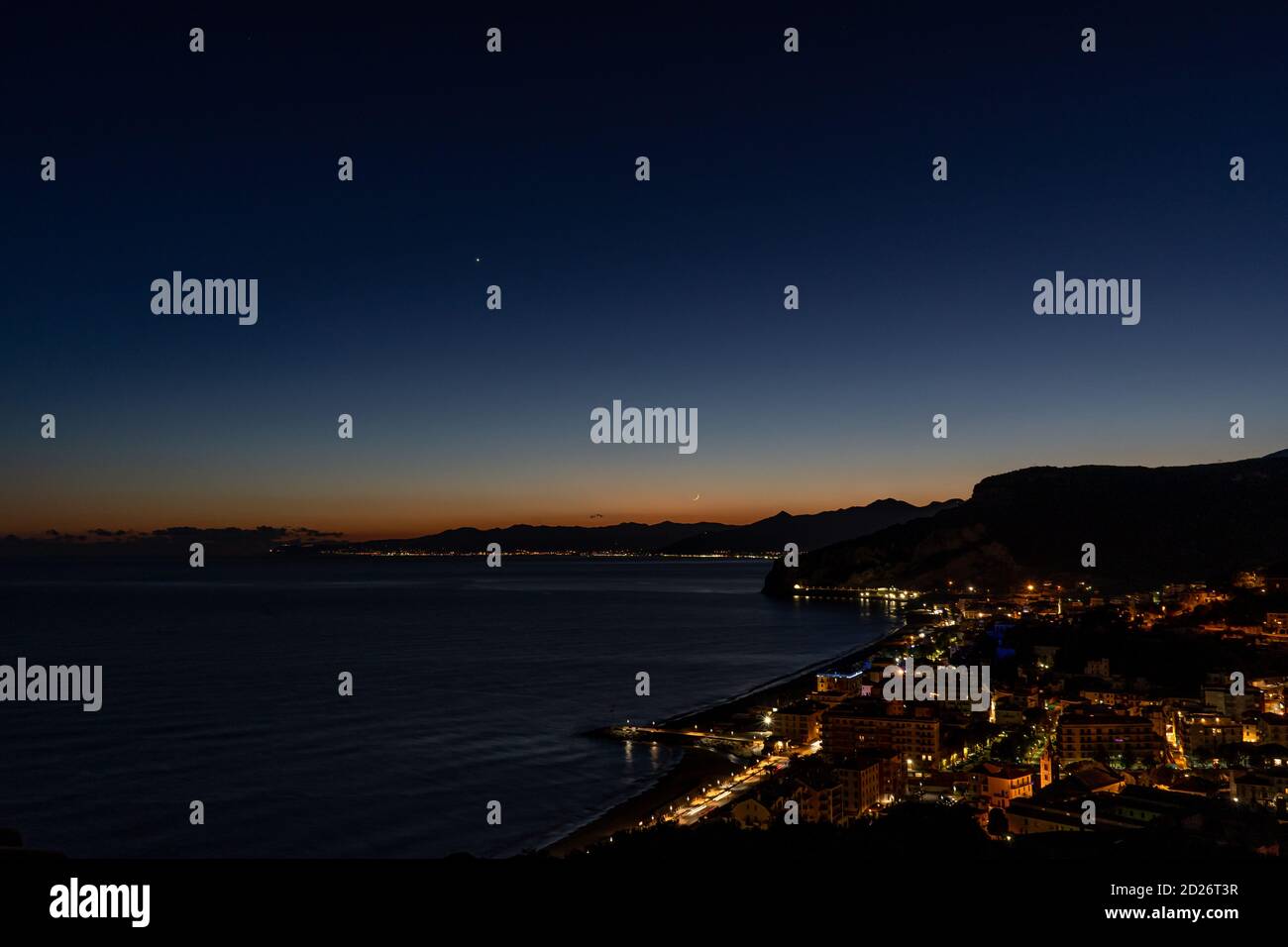 Dünner Mond an einem ruhigen und kalten Strand in Finale Ligure Stockfoto