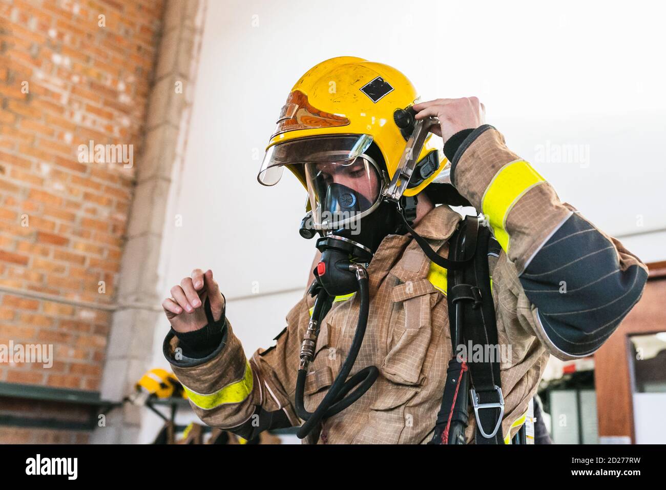 Nicht erkennbarer Feuerwehrmann mit gelbem Helm und Sauerstoffmaske Stockfoto