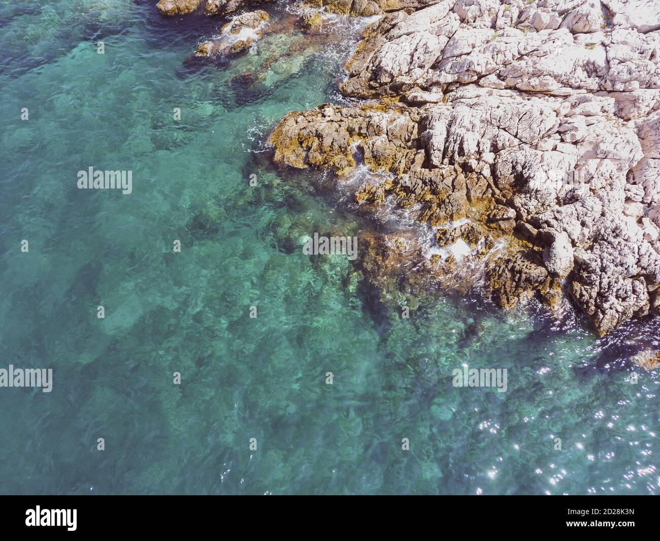 Kristallklares Meer, das weiße, steinerne Felsen vor der Küste von Rogoznica, Kroatien, beliebtes Touristenziel in Mitteldalmatien Stockfoto