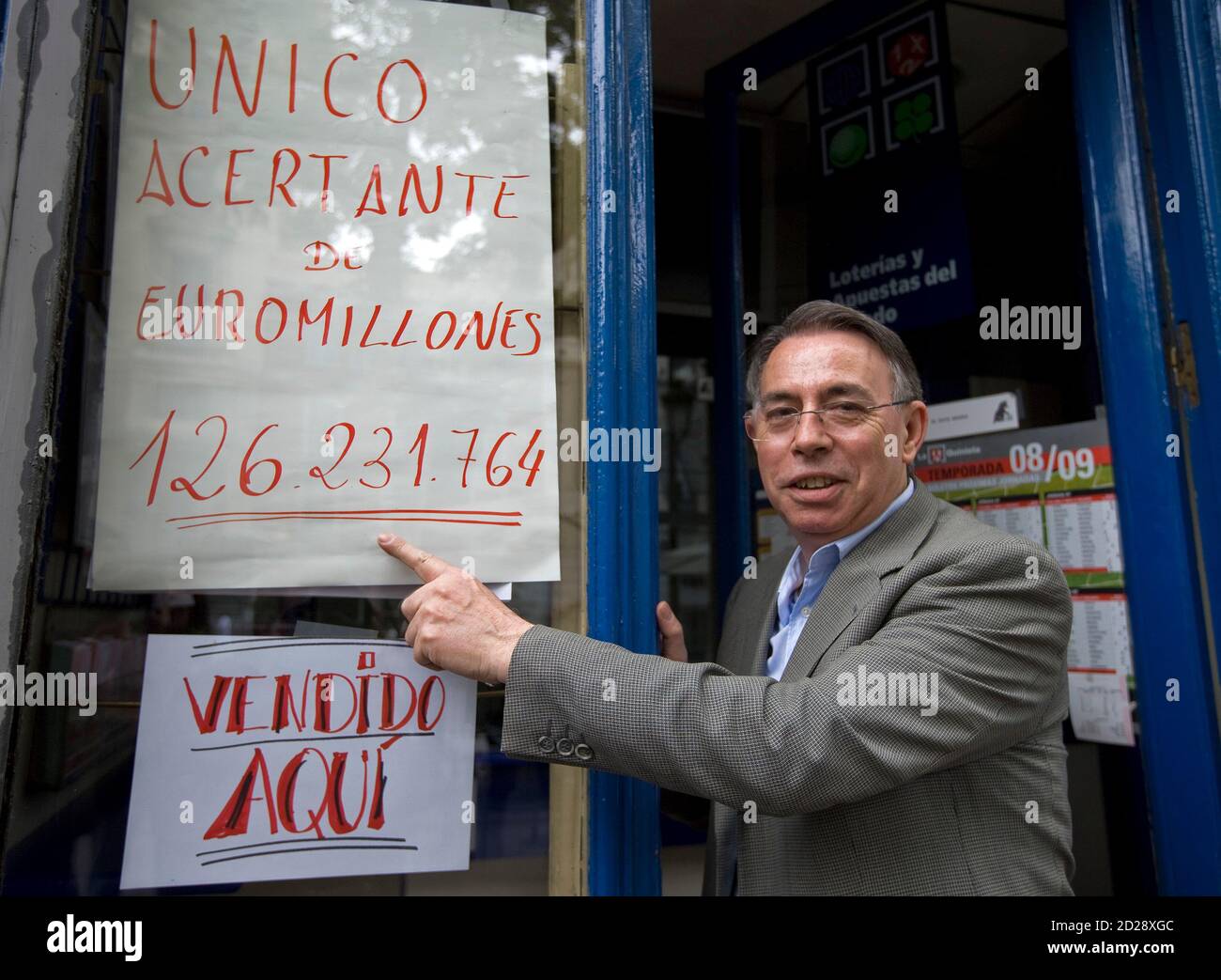 Agustin Marcos, Angestellter der Black Cat-Lotto-Kiosk im Zentrum von  Madrid, verweist auf ein Schild mit der Aufschrift "Alleiniger Sieger von  Euro Millions 126.231.764" in Madrid, 9. Mai 2009. Ein Lotto-Spieler in  Spanien