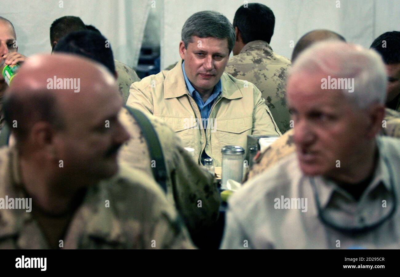 Kanadas Premierminister Stephen Harper (C) isst Frühstück mit Mitgliedern der kanadischen Streitkräfte auf dem Flugplatz Kandahar in Kandahar, Afghanistan 23. Mai 2007. REUTERS/Chris Wattie (AFGHANISTAN) Stockfoto