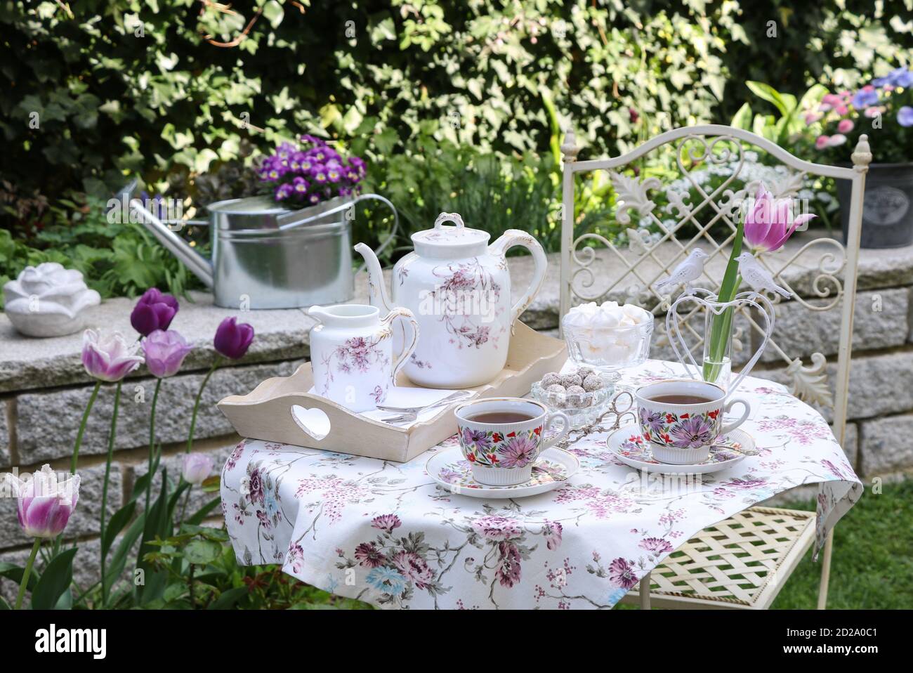 Tischdekoration mit Vintage Porzellan und Baiser im Frühlingsgarten Stockfoto