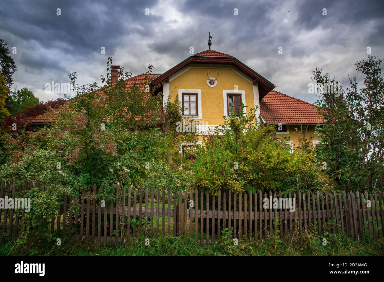Gepflegtes gelbes Forsthaus im Waldviertel, Österreich an einem bewölkten Herbsttag, Landidylle Stockfoto