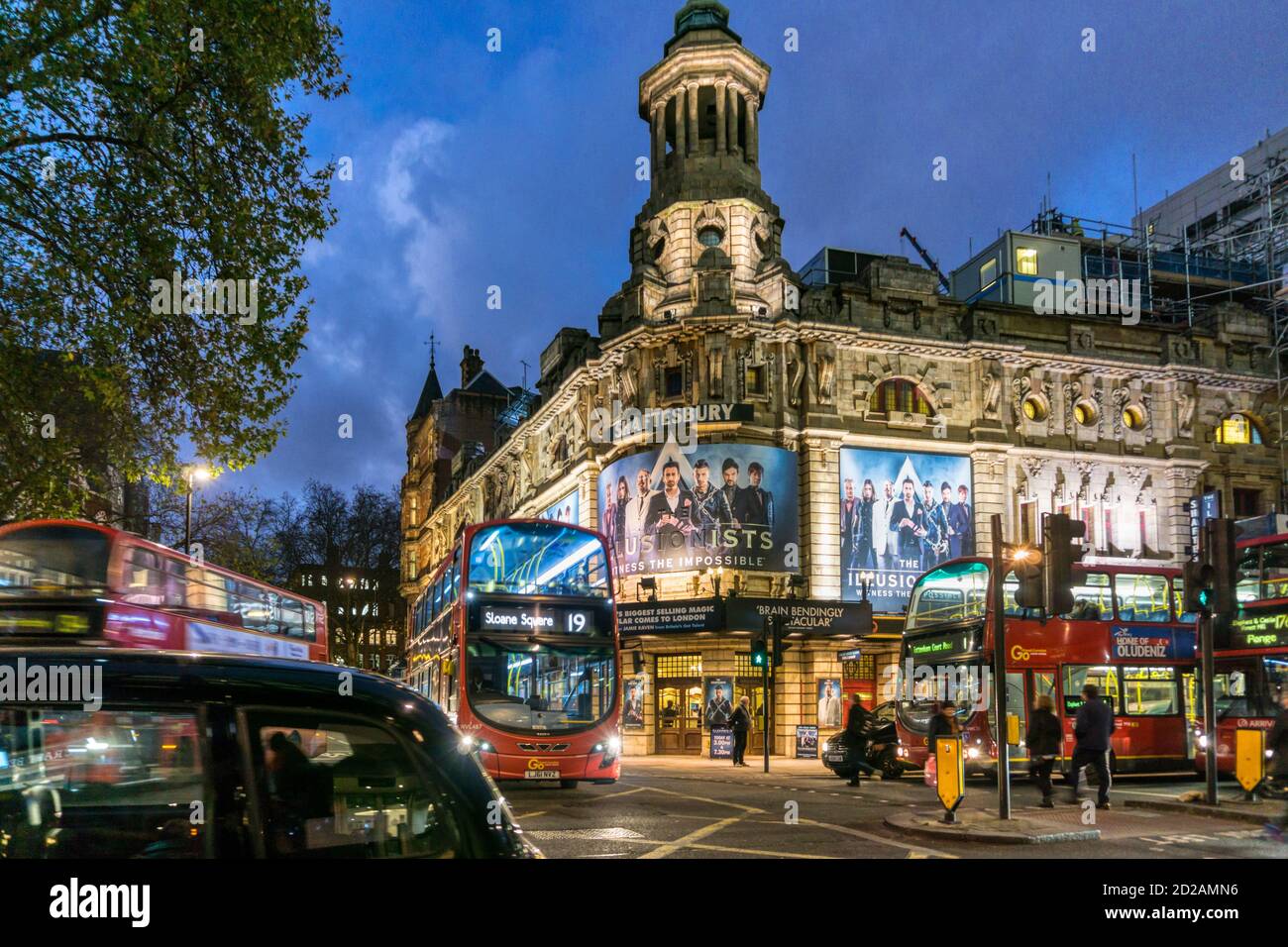 Rote Busse und schwarze Taxis fahren nachts am Shaftesbury Theatre im West End von London vorbei. Stockfoto