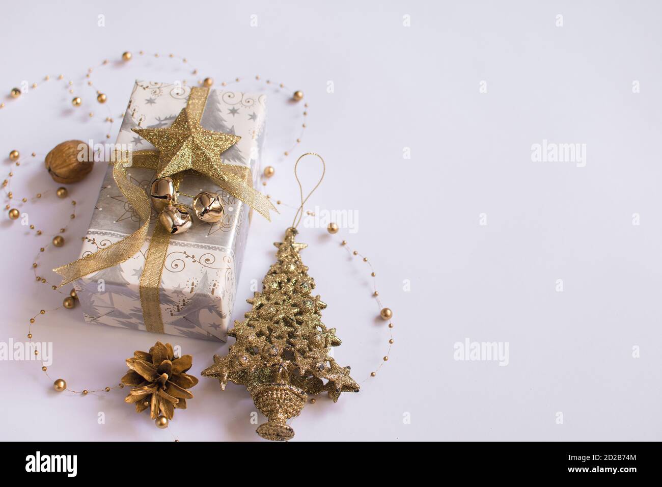 Weihnachtskomposition. Weihnachtsgeschenk, Kiefer, Nuss, auf weißem Hintergrund. Stockfoto