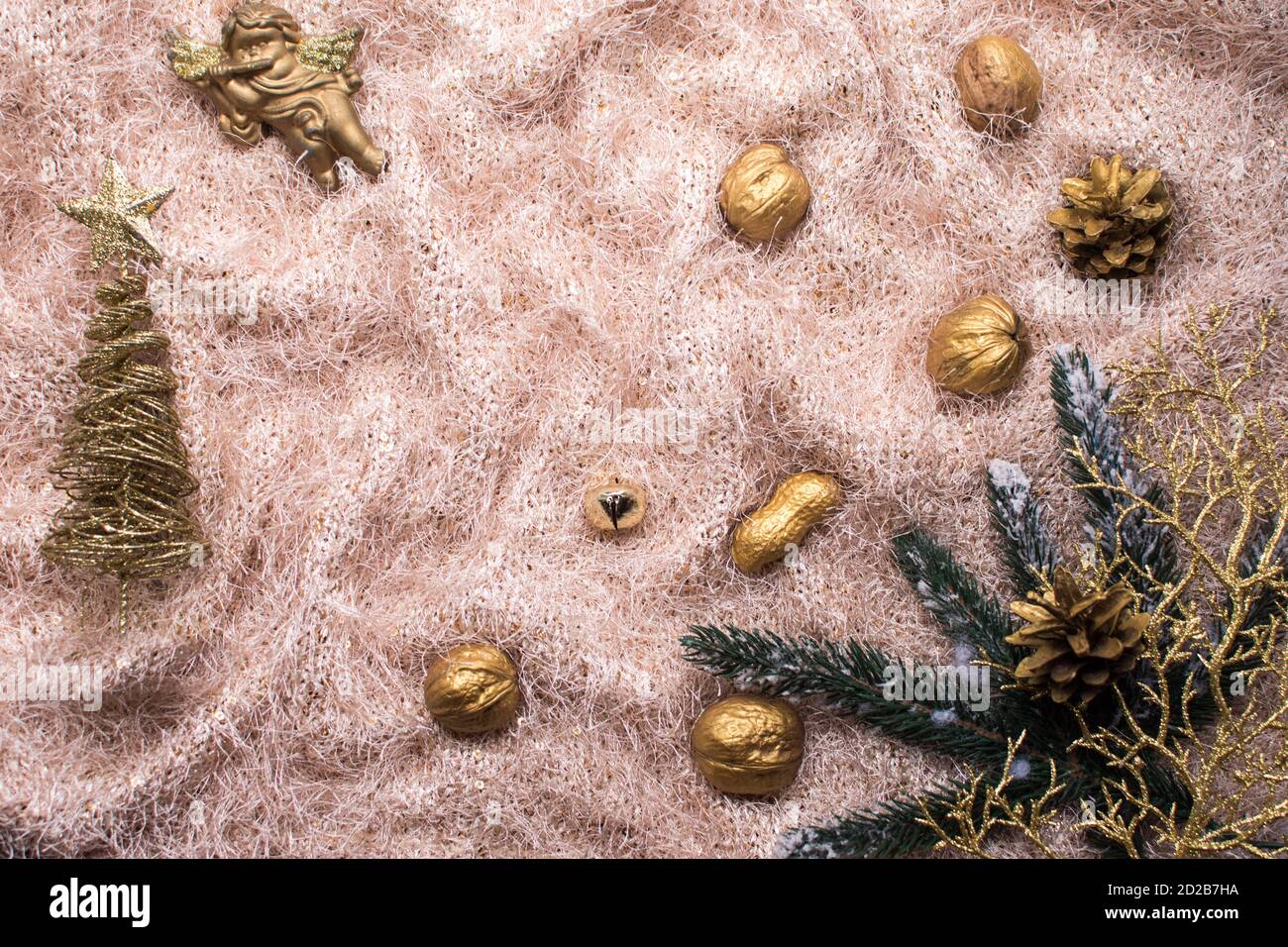 Weihnachts-Layout auf einem Stoffhintergrund. Attribute des neuen Jahres. Christbaumzweige, goldene Nüsse, Fichtenzweig, goldener Baum. Stockfoto