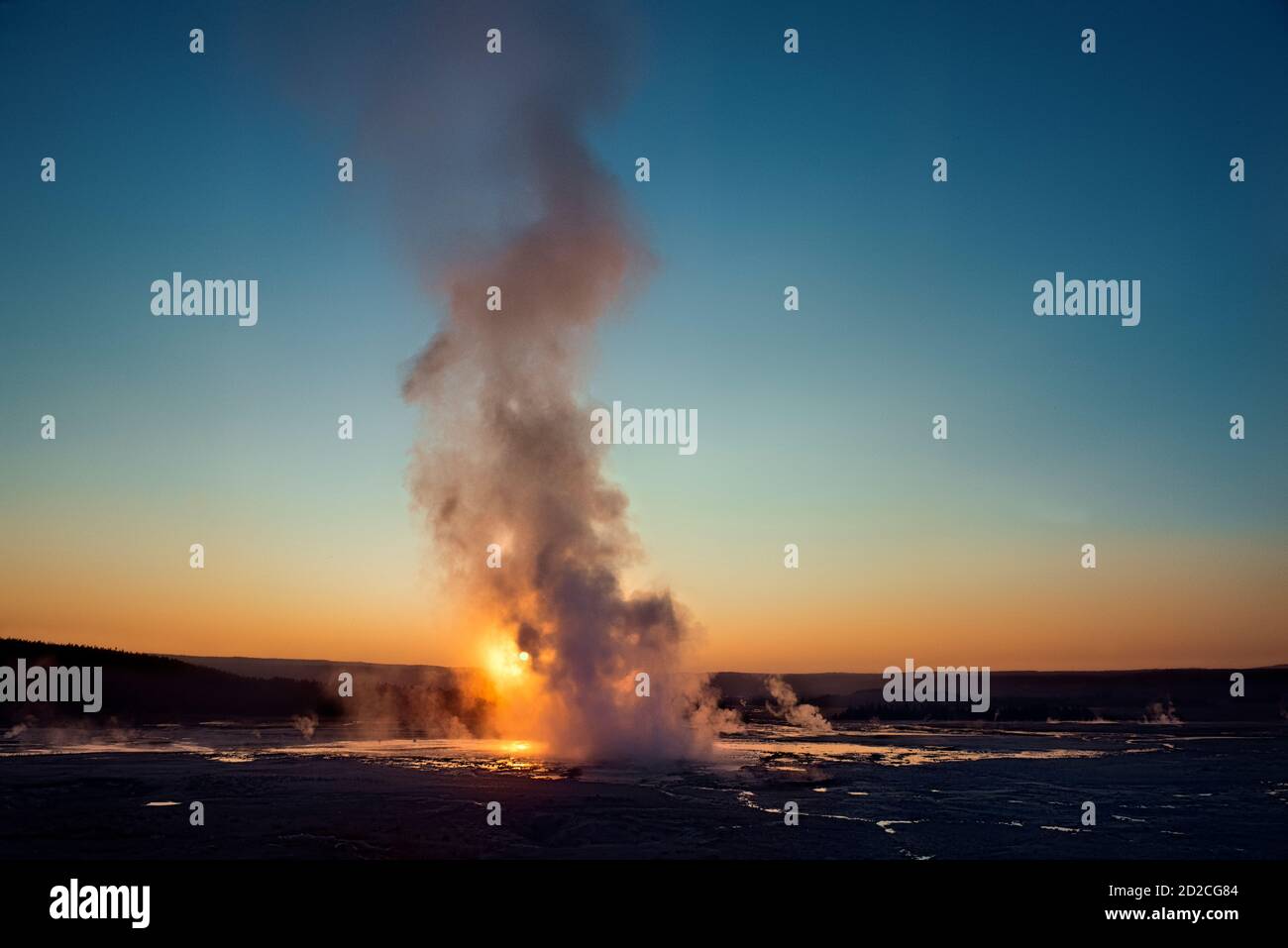 Clepsydra Geyser, der bei Sonnenuntergang ausbricht, Lower Geyser Basin, Yellowstone National Park, Wyoming, USA Stockfoto