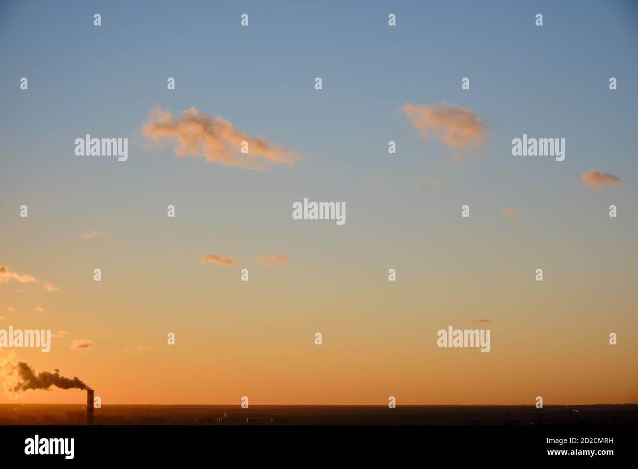 Orangefarbener Sonnenuntergang, Wolken bei klarem Wetter, Kopierraum. Roter Abendhimmel bei Sonnenuntergang, Fabrikkamin mit Rauch. Hintergrund Wolken auf Sonnenuntergang Himmel. Stockfoto