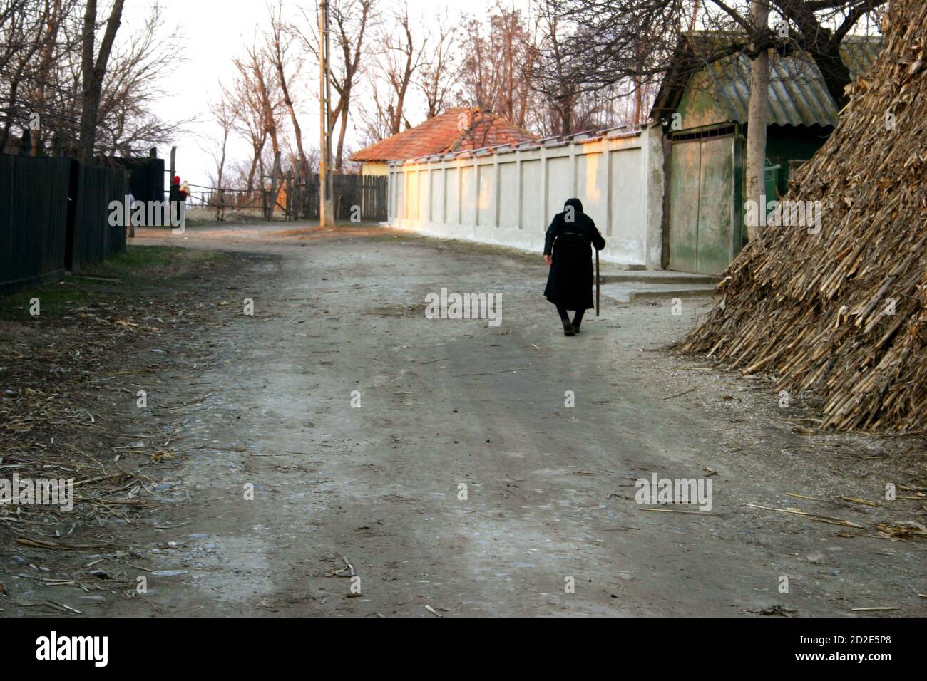Ialomita County, Rumänien. Ältere Frau, die auf dem Dorfweg geht. Stockfoto