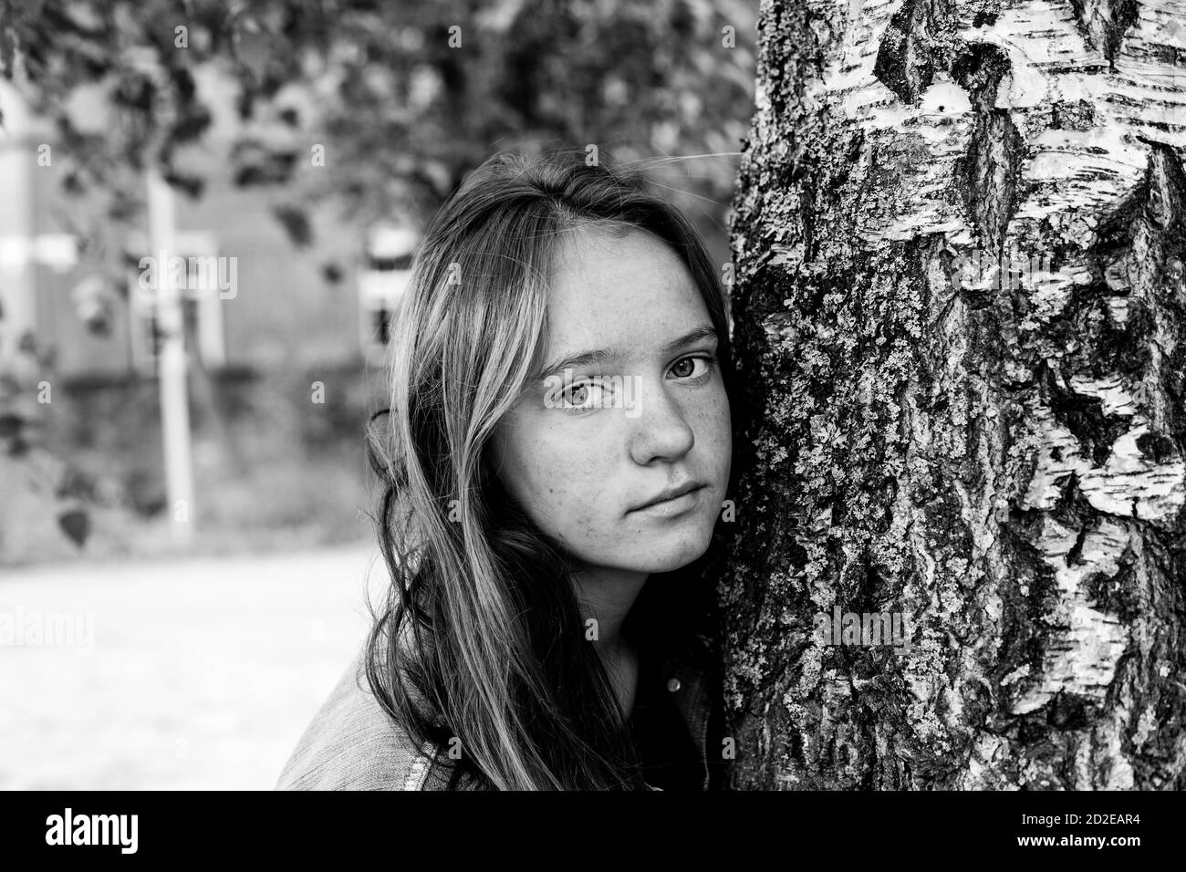 Teen Mädchen mit langen Haaren Porträt in der Nähe des Baumes. Schwarzweiß-Fotografie. Stockfoto