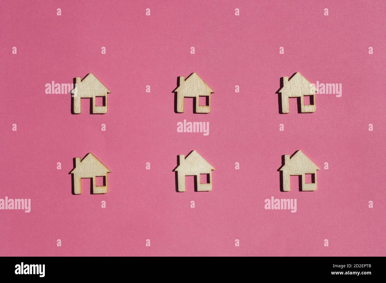 Mini Holzhäuser auf rosa Hintergrund Stockfoto