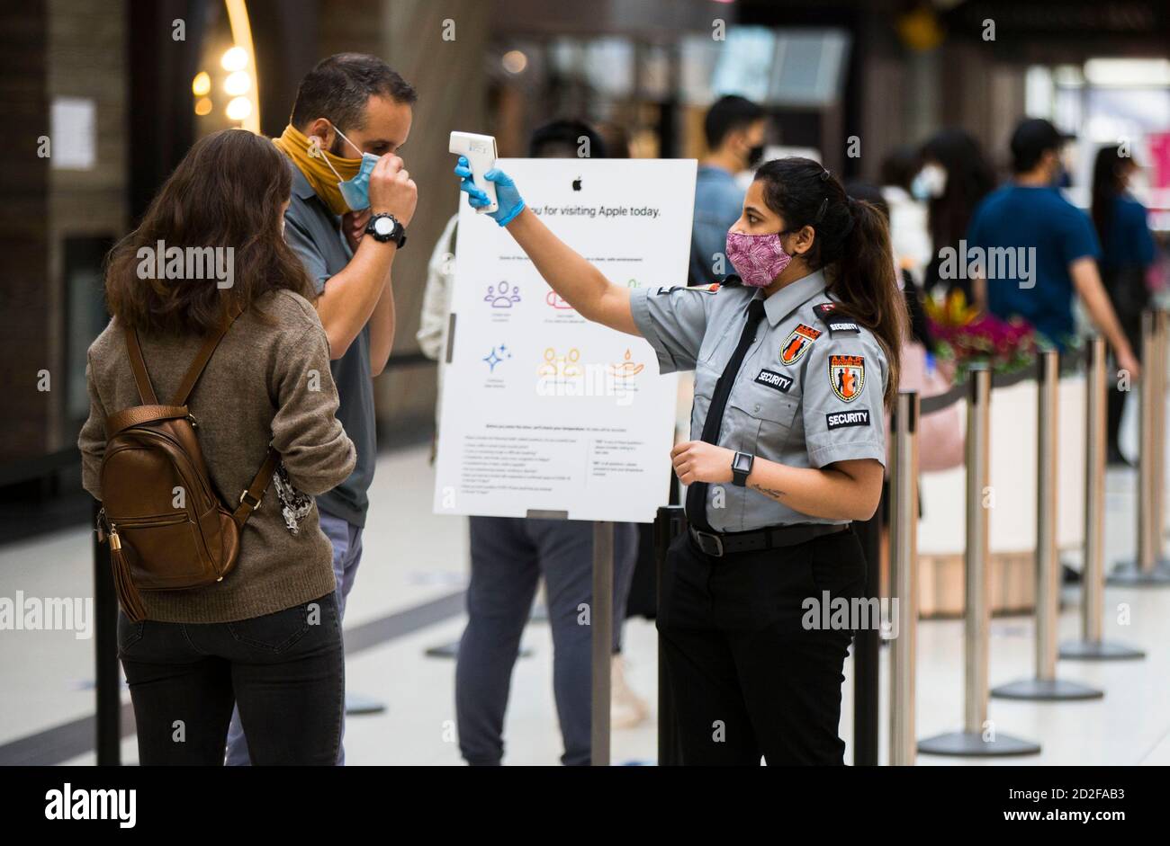 Toronto, Kanada. Oktober 2020. Ein Sicherheitsbeauftragter mit Gesichtsmaske überprüft am 6. Oktober 2020 die Temperatur eines Kunden außerhalb eines Apple-Stores in Toronto, Kanada. Kanadas tägliche Fälle von COVID-19 sind weiter gestiegen. Am Dienstagnachmittag meldete das Land laut CTV insgesamt 170,945 Fälle von COVID-19, darunter 9,527 Todesfälle. Quelle: Zou Zheng/Xinhua/Alamy Live News Stockfoto