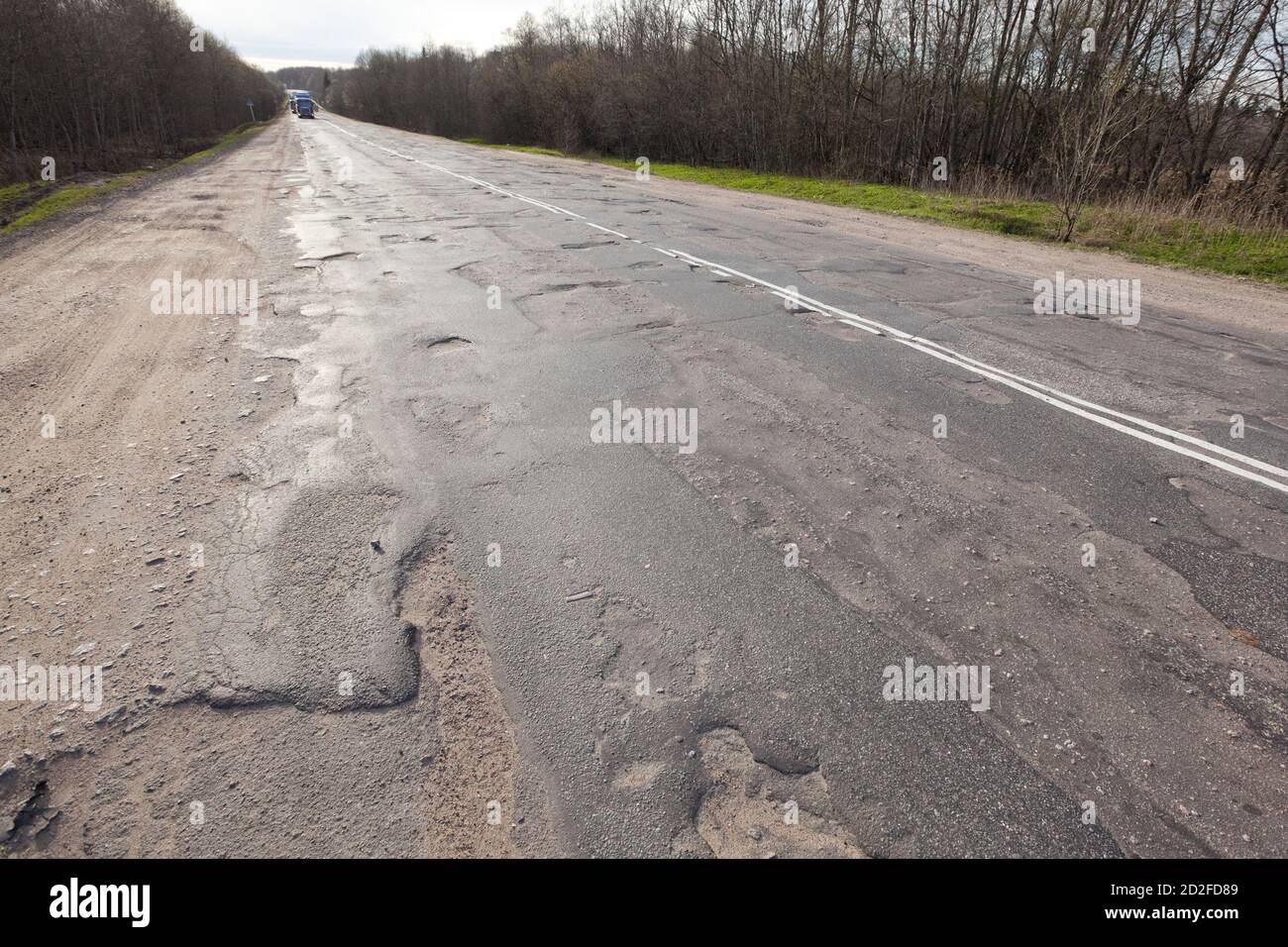 Schlechte Straße mit Schlaglöchern. Loch in Asphalt, schlechter Asphalt. Pit, unsicher, Hole Road. Transport, Zerstörung von Straßen, Gefahr der Bewegung mit dem Auto Stockfoto