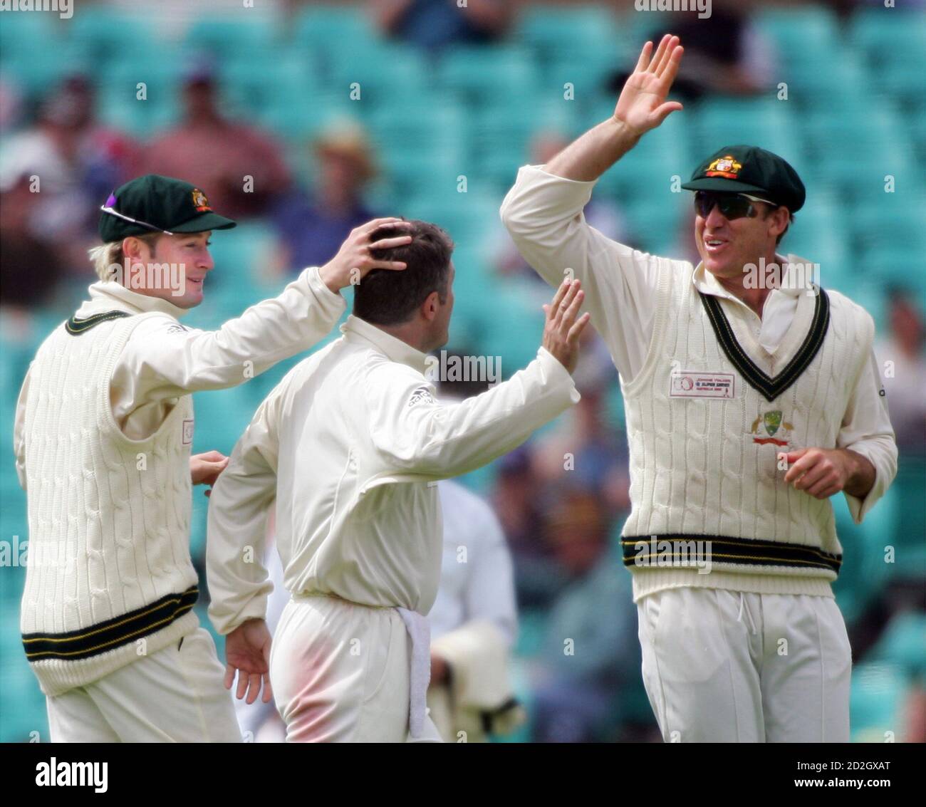 Matthew Hayden von Australia (R) ist zusammen mit Teamkollege Michael Clarke (L) wie sie Stuart MacGill (C) gratulieren, der World XI hatte Andrew Flintoff gefangen für 15 am Tag vier der Grille Super Test in Sydney 17. Oktober 2005 läuft. Die Weltauswahl kämpften, um eine massive Niederlage im super-Test gegen Australien zu vermeiden, nach dem Verlust von drei schnelle Pforten am vierten Tag auf Monday.REUTERS/Will Burgess Stockfoto