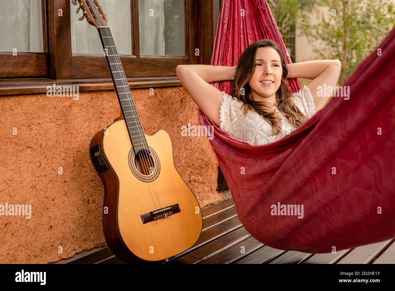 Entspannte Frau in Hängematte vor einem Schlammhaus Stockfoto