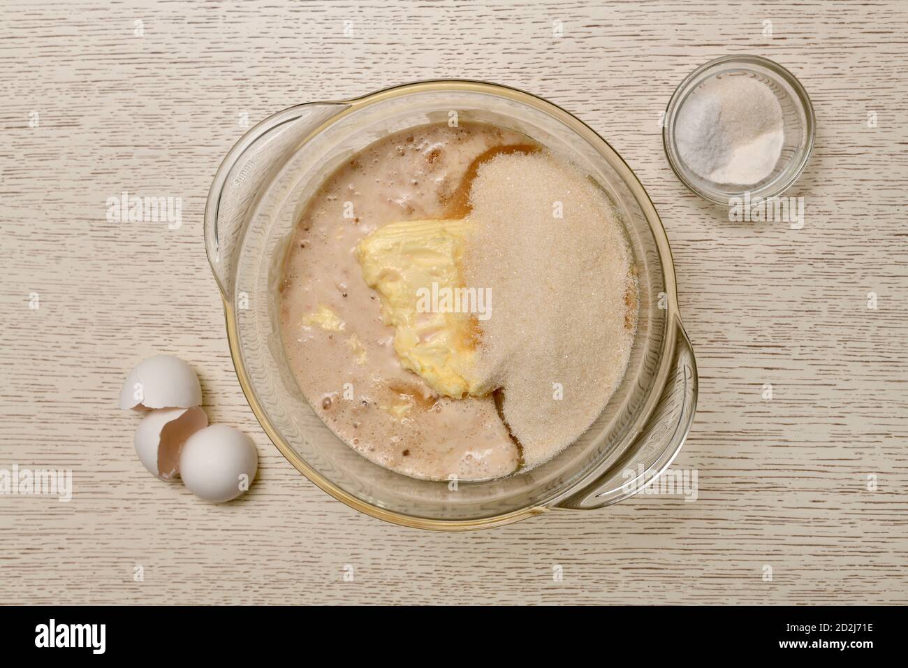 Der Schritt des Hinzufügens von Salz, Backpulver und Vanille zu einer Mischung. Teigzubereitung. Stockfoto