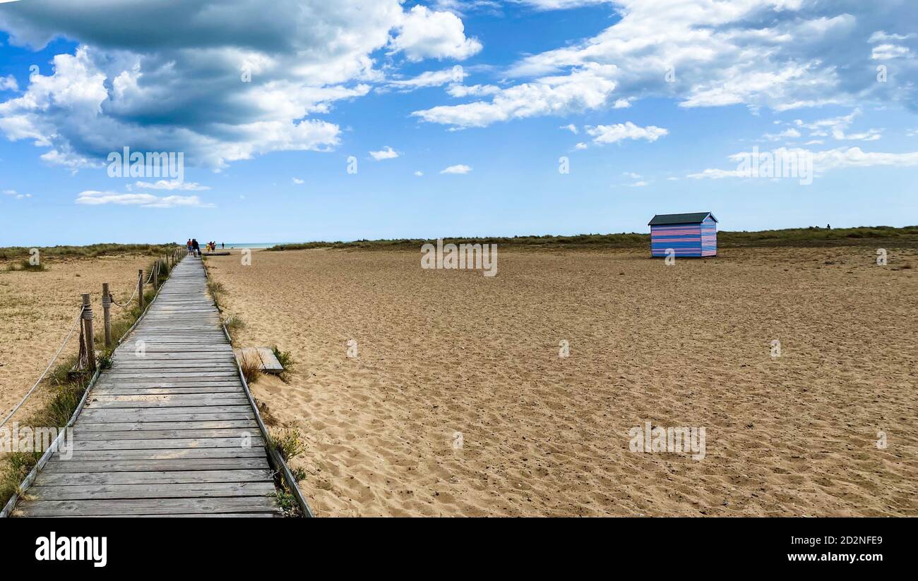 Tolle Strandhütten in Yarmouth an einem Sommertag, traditionelle britische Hütte an einer englischen Ostküste, blaue und rosa horizontale Streifen, Himmel mit Wolken ohne Peopl Stockfoto