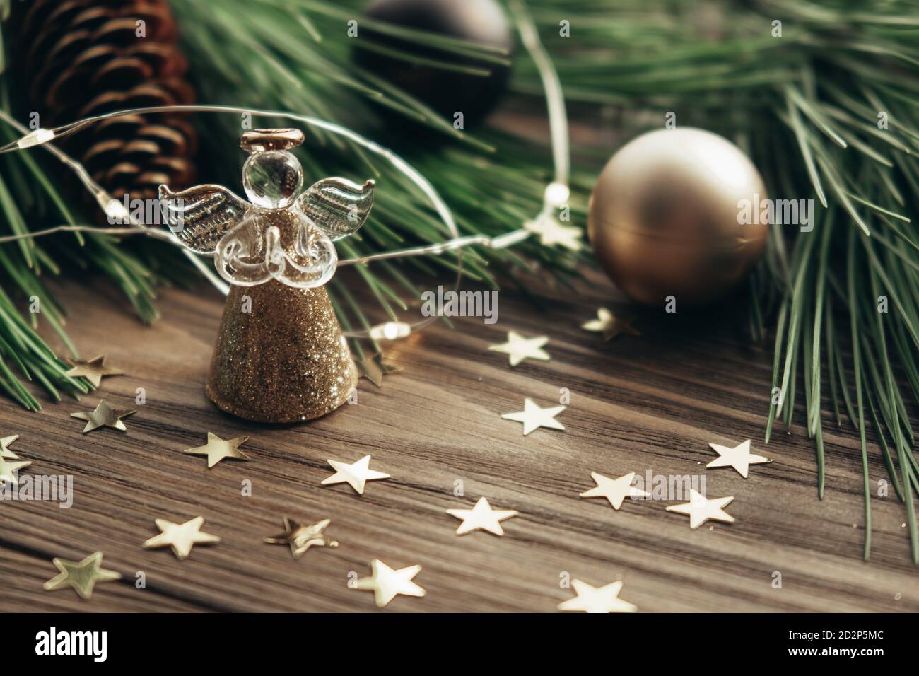 Weihnachtliche festliche Hintergrund mit Engel, Tannenzweige, Dekorationen und Girlande auf einem hölzernen Hintergrund. Frohe Weihnachten. Selektiver Fokus. Nahaufnahme. Stockfoto