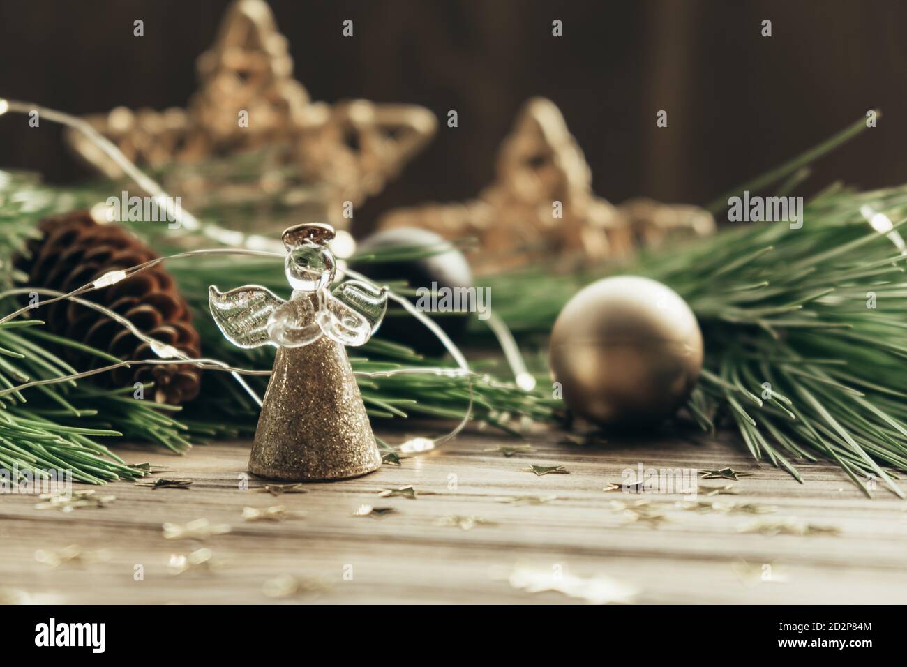 Weihnachtliche festliche Hintergrund mit Engel, Tannenzweige, Dekorationen und Girlande auf einem hölzernen Hintergrund. Frohe Weihnachten. Selektiver Fokus. Nahaufnahme. Stockfoto